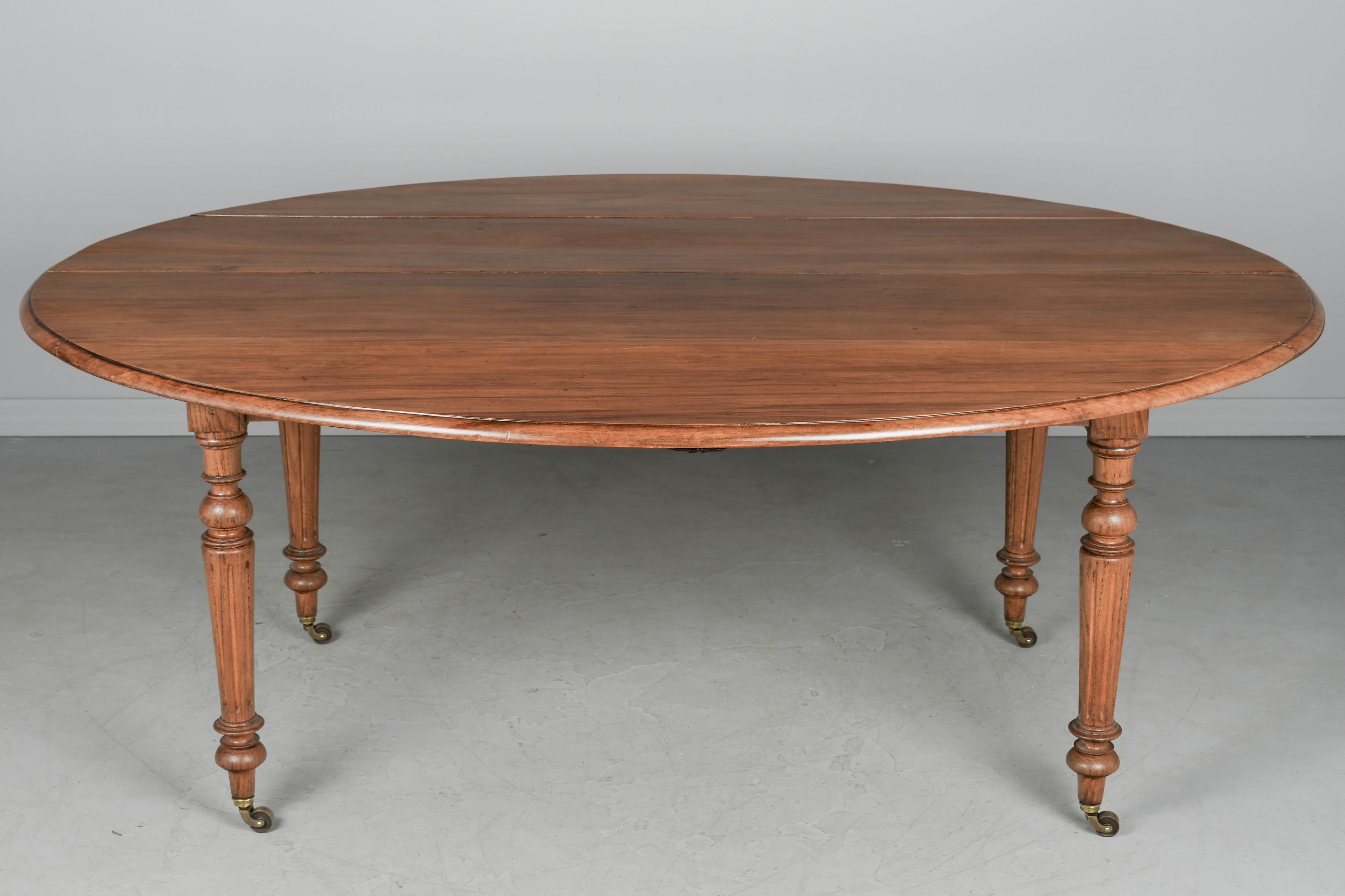 Mesa de comedor ovalada de estilo Louis Philippe de Normandía de principios del siglo XX. La parte superior está hecha de cuatro tablones de cerezo macizo y las patas son de roble torneado con ruedas nuevas de latón. Acabado encerado. Una mesa