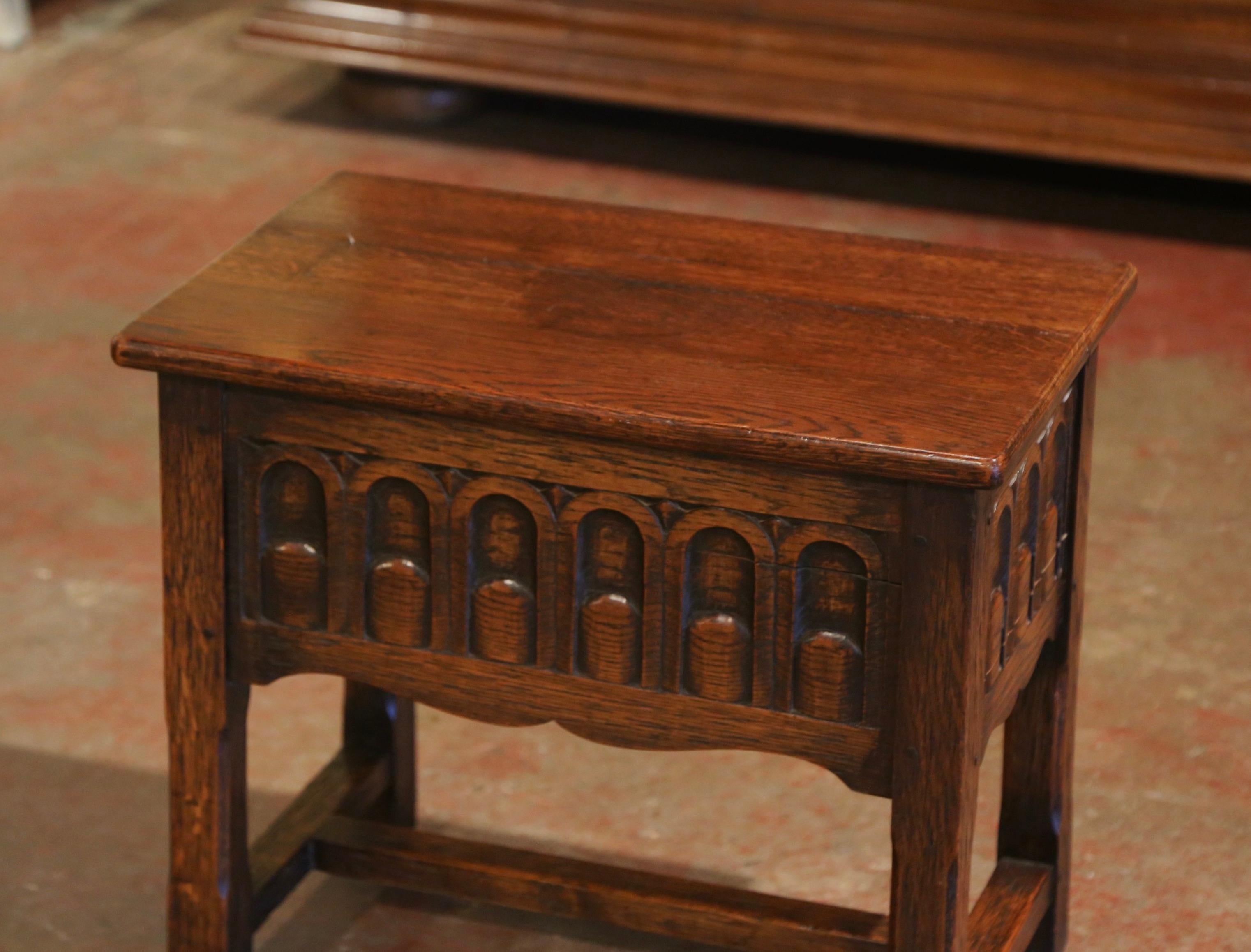 This elegant antique coffer table bench was crafted in France, circa 1920. The sturdy, Louis XIV style side table stands on square legs embellished with a bottom stretcher. All three sides feature hand carved panels with geometric motifs over a