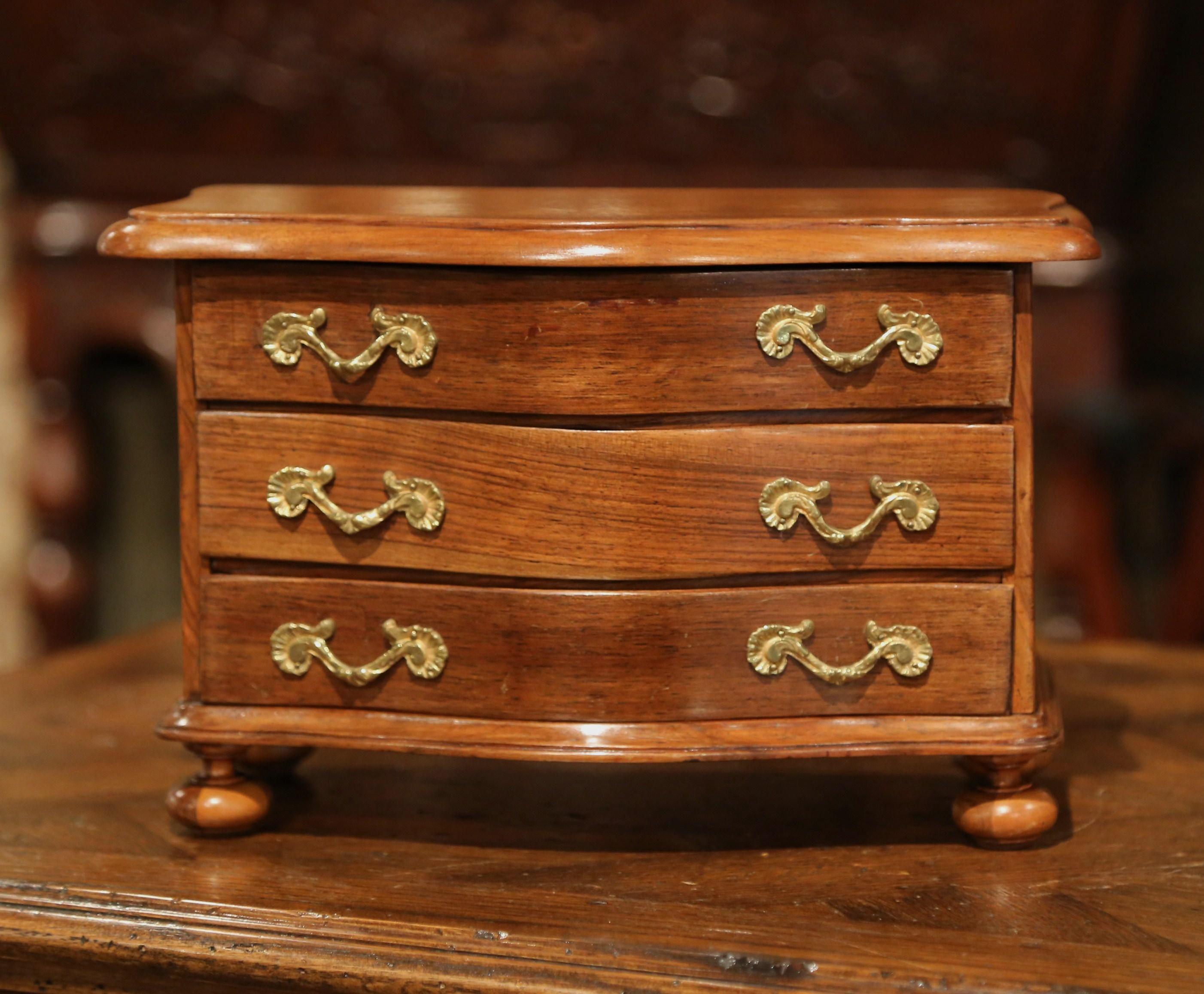 Decorate a master bathroom counter with this miniature chest of drawers. Crafted in France, circa 1920, the petite fruitwood 