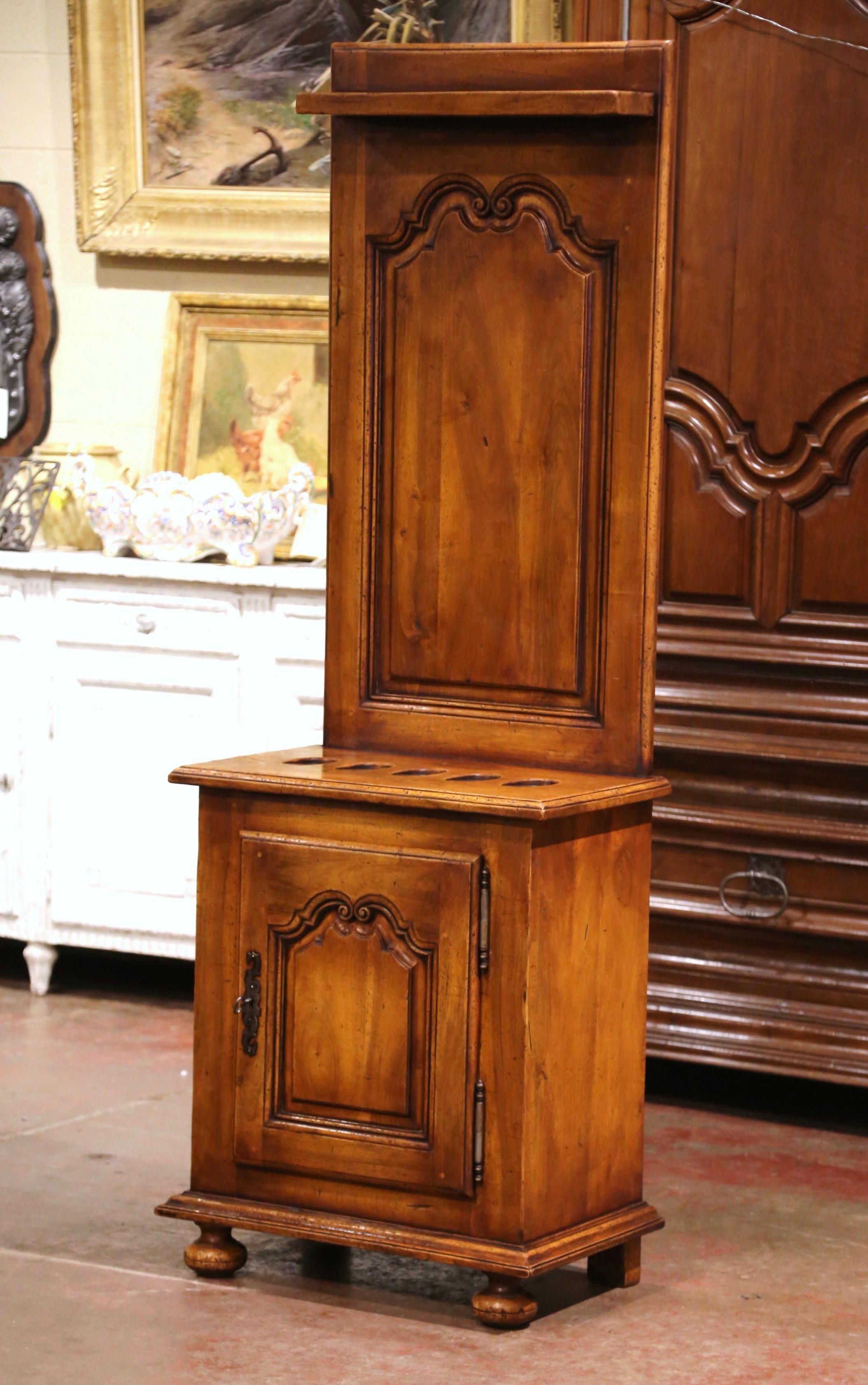 Decorate a ranch house or hunting lodge with this exquisite antique gun cabinet. Crafted in southern France, circa 1920, the tall cabinet stands on bun feet over a small straight plinth. It features a carved door with recessed panel, opening to
