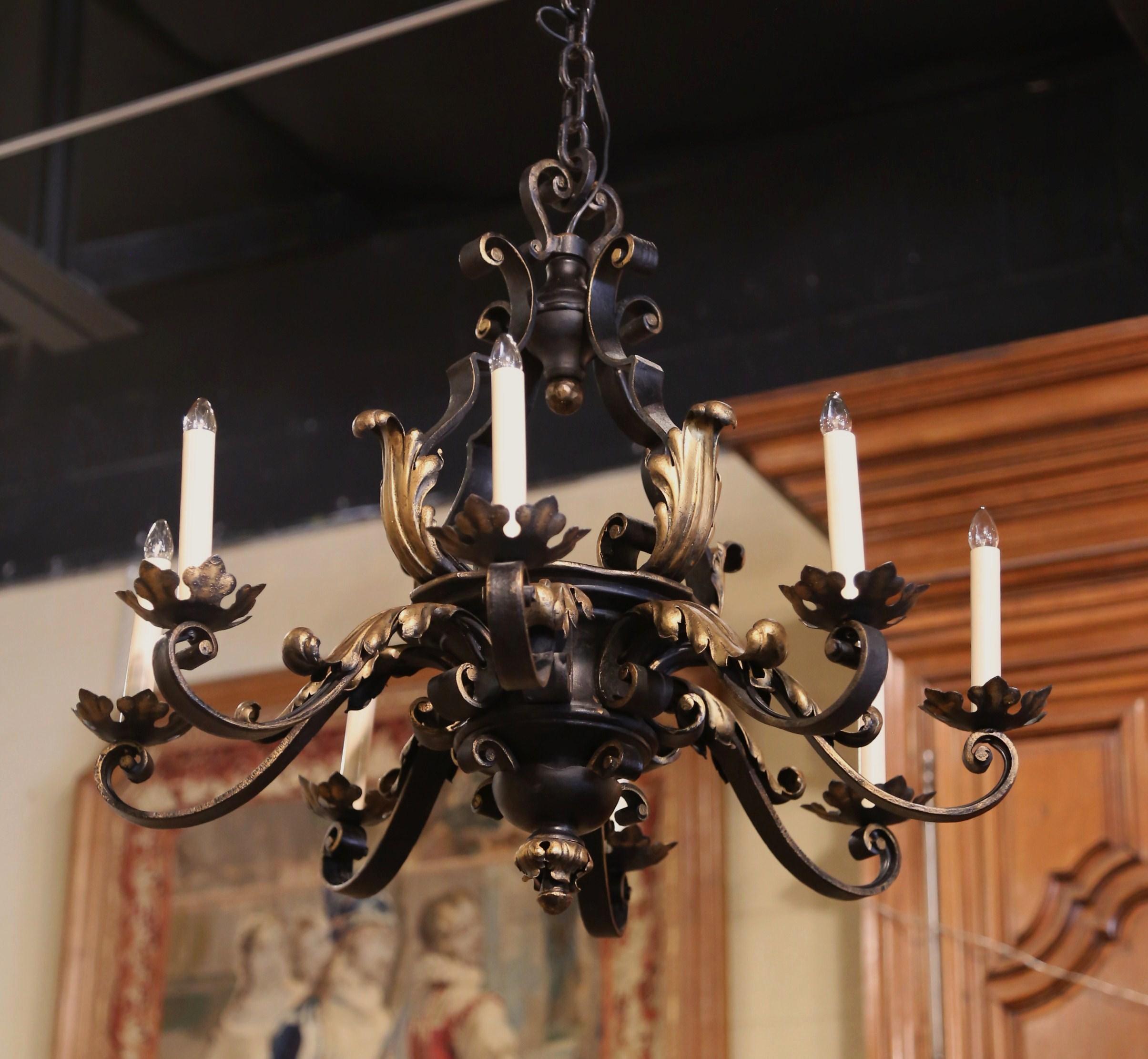 This elegant antique iron chandelier was created in France, circa 1920. Round in shape, the scrolling chandelier is decorated with a central decorative motif with inside finial; it has eight, wired arms embellished with metal acanthus leaves and