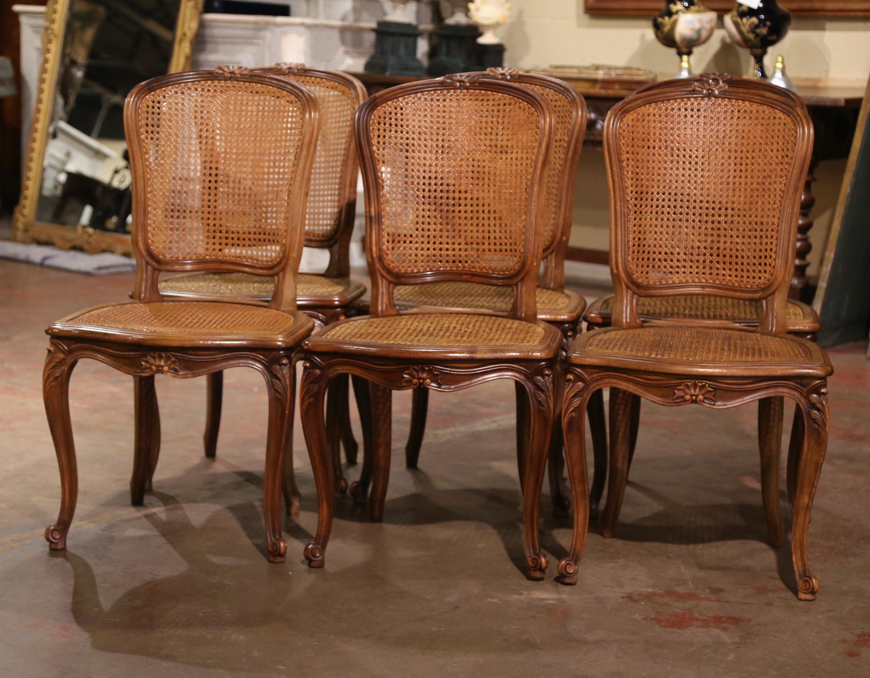Decorate a dining table with this elegant suite of antique side chairs. Crafted in France circa 1970, and built of walnut, each dining chair stands on cabriole legs decorated with acanthus leaves at the shoulder ending with escargot feet. The chair