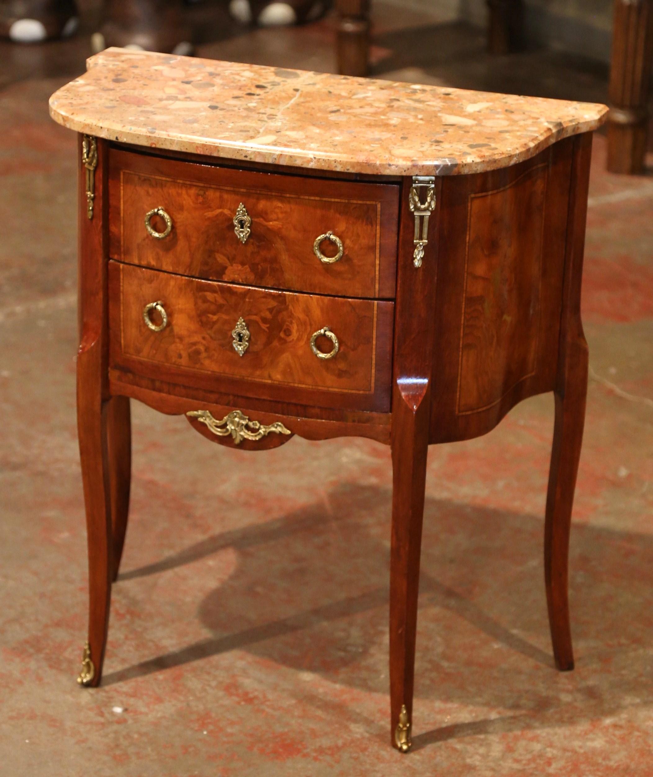 Decorate an living room with this elegant antique chest. Crafted in France, circa 1920, the cabinet sits on cabriole legs decorated with bronze caps over the feet. The fruitwood commode features two serpentine drawers across the front with inlay and
