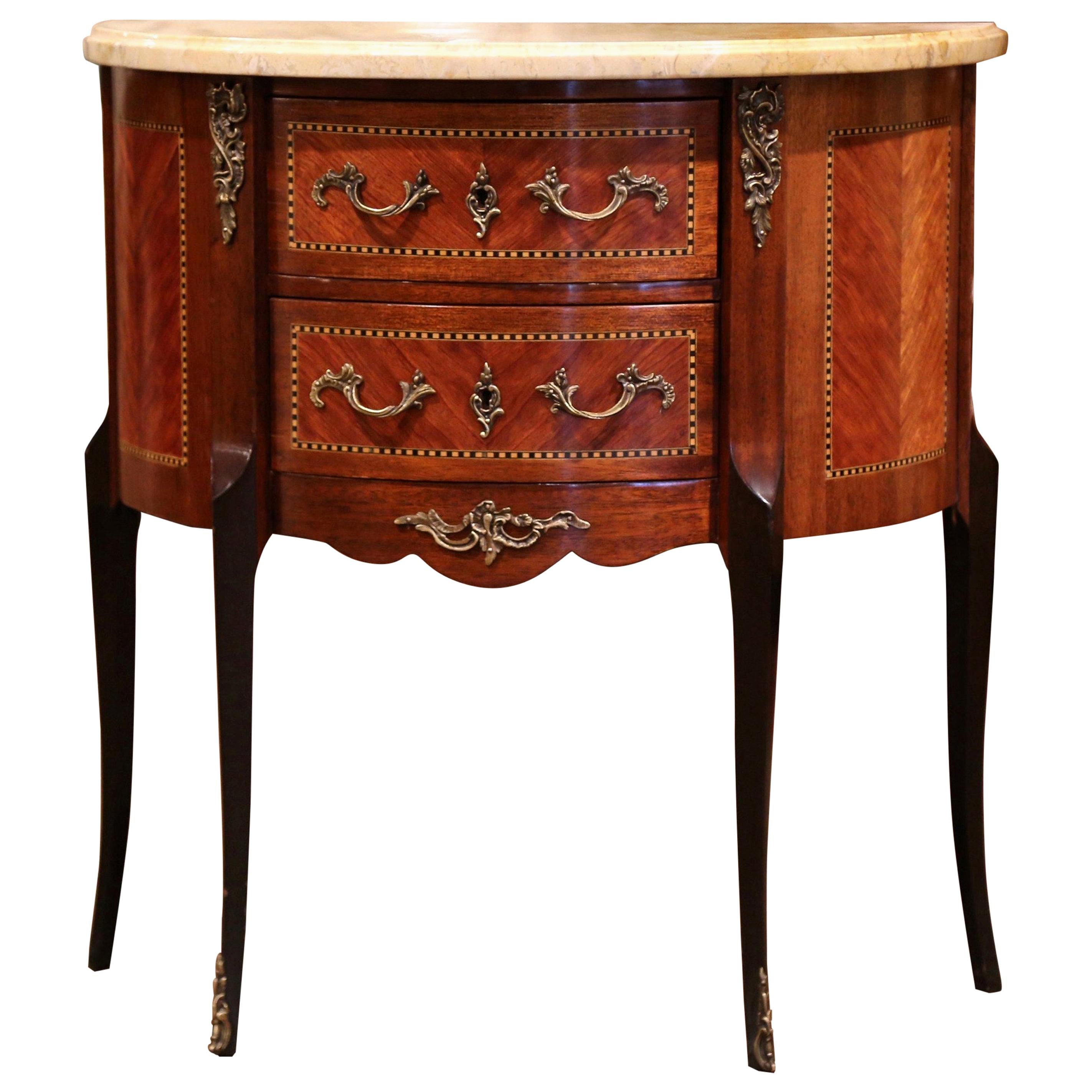 Decorate a living room with this elegant antique chest of drawers; crafted in France, circa 1920 and shaped as half-moon, the cabinet sits on cabriole legs with bronze caps over the feet. The fruitwood commode features two bombe drawers across the
