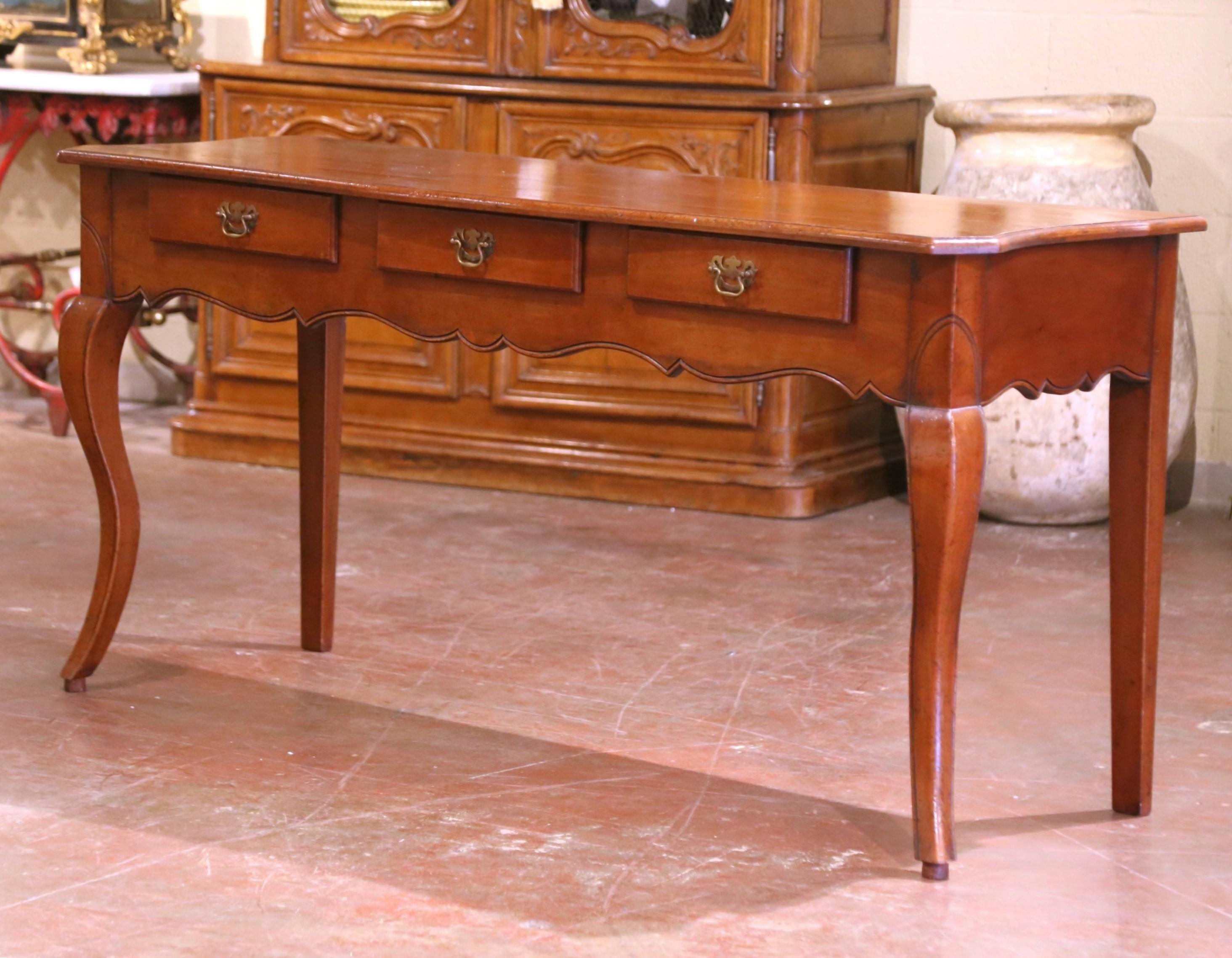 Dress an entryway or living room with this elegant antique console table. Crafted in southern France around 1920, the table is made of solid walnut and features a beautifully scalloped apron and shaped top, typical of the French Louis XV style. The