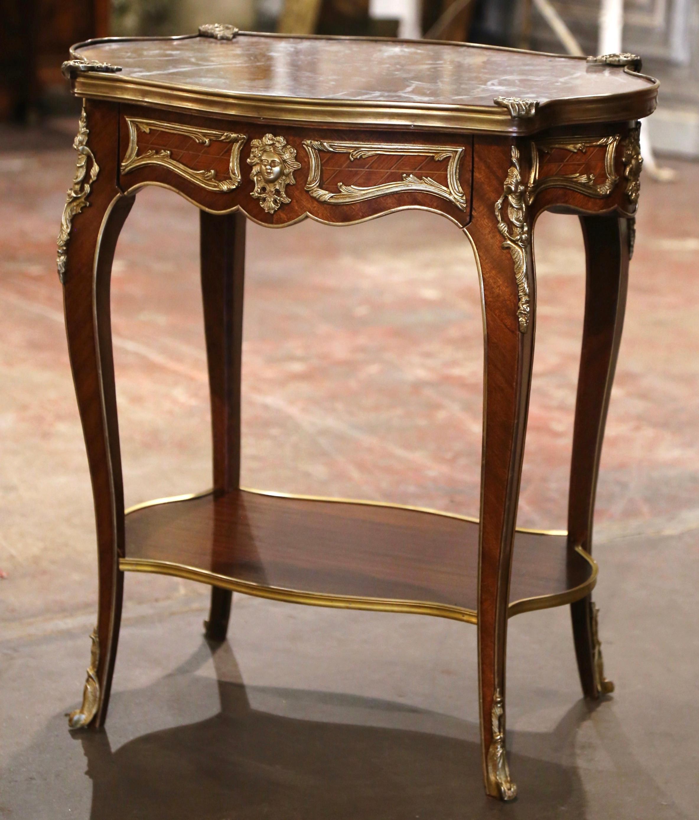 Decorate an entry or hallway with this elegant antique side table. Crafted in France circa 1920 and built of walnut with ormolu embellishments, the classic cabinet exemplifies the Louis XV style with a heavy presence, dramatic lines and beautiful