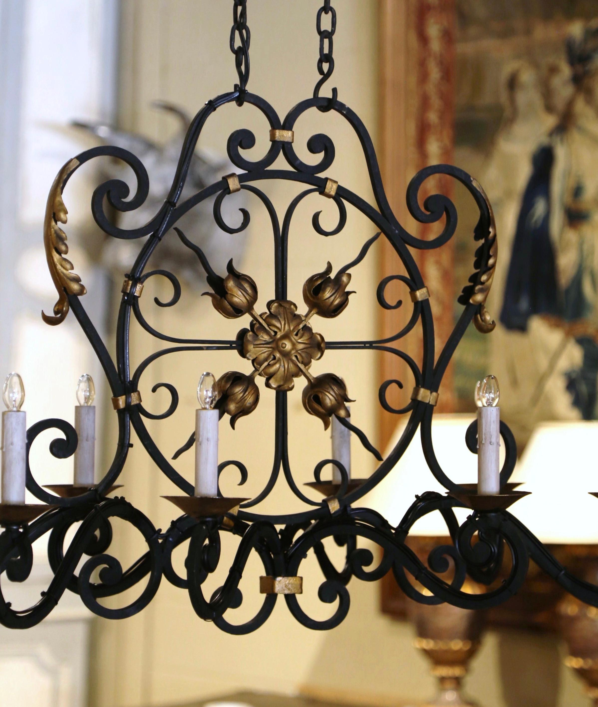 Decorate a kitchen with this elegant, antique iron chandelier, Crafted in Normandy France, circa 1920, and oblong in shape, the fixture with scroll motifs, features a center round floral medallion with four roses around it, embellished by decorative