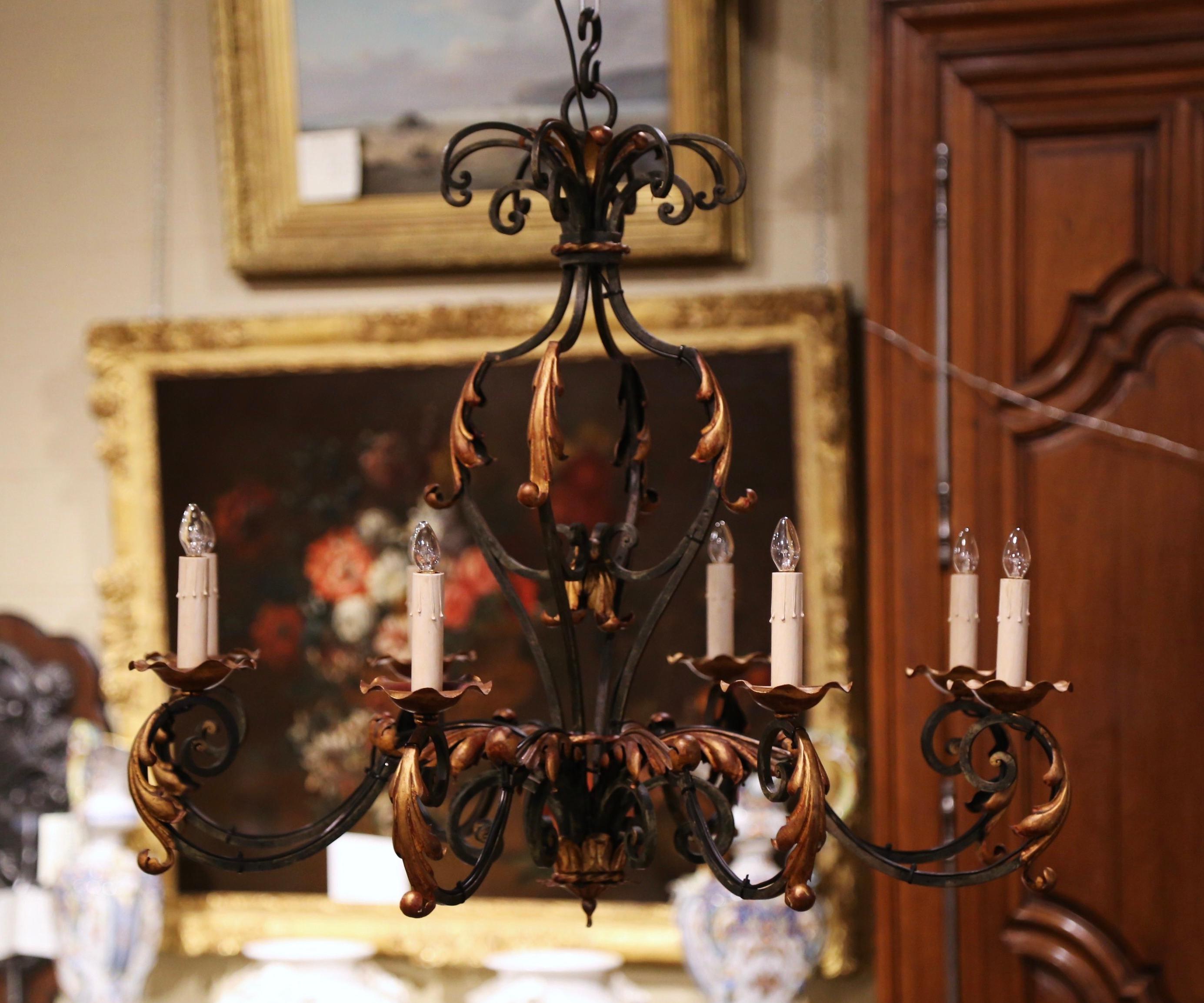 This elegant, antique chandelier was created in Paris, France circa 1920. Round in shape, the Louis XV style iron chandelier features forged scrolled motifs decorated with metal acanthus leaves throughout. The fixture has six arms, and each light is