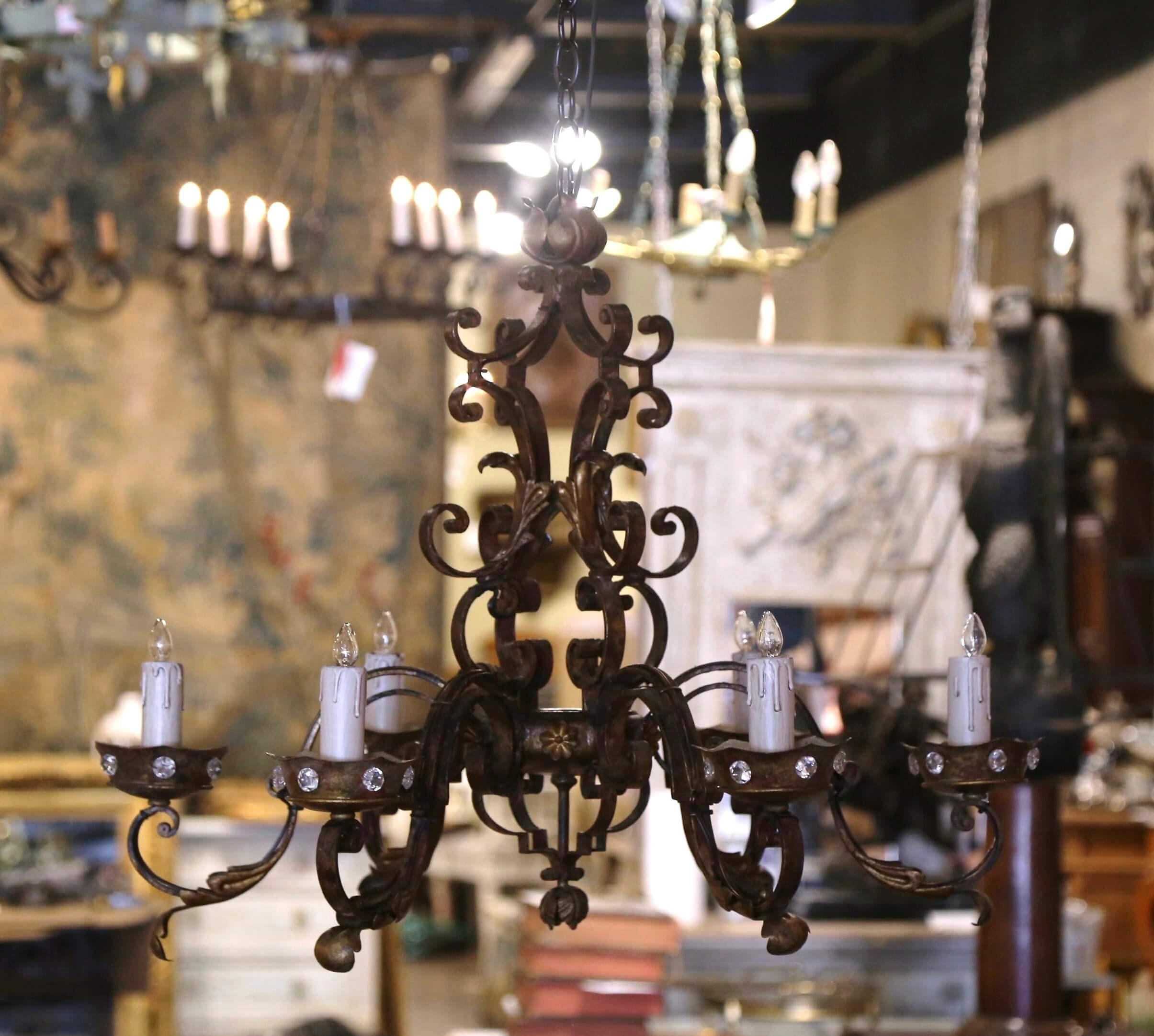 This elegant antique chandelier was created in France, circa 1920. Round in shape, and built of iron, the chandelier features a center quadruple stem. The fixture has six forged double scroll arms newly wired, embellished with metal acanthus leaves,