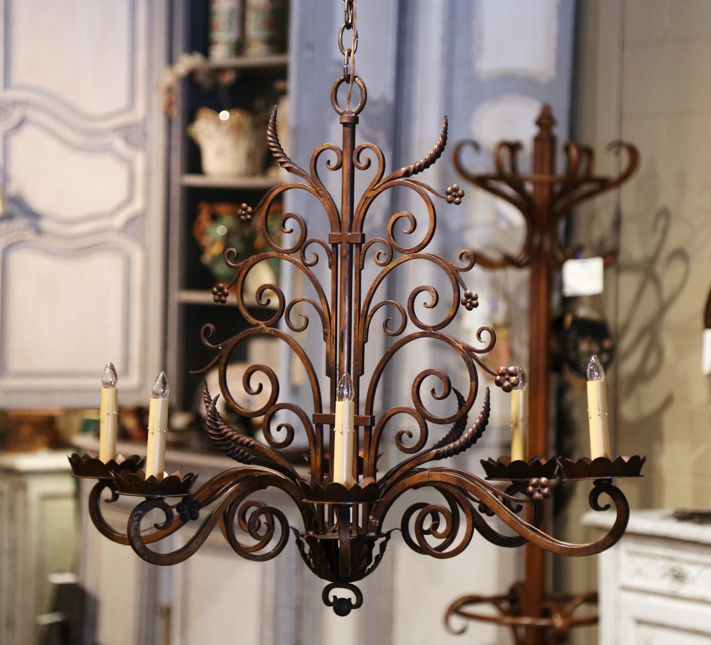 This elegant, scrolling, oblong chandelier would make a lovely addition to a breakfast or dining room. Crafted from iron, the chandelier was made in France, circa 1900. The large chandelier with metal flowers, twisted and scrolled decor, has six