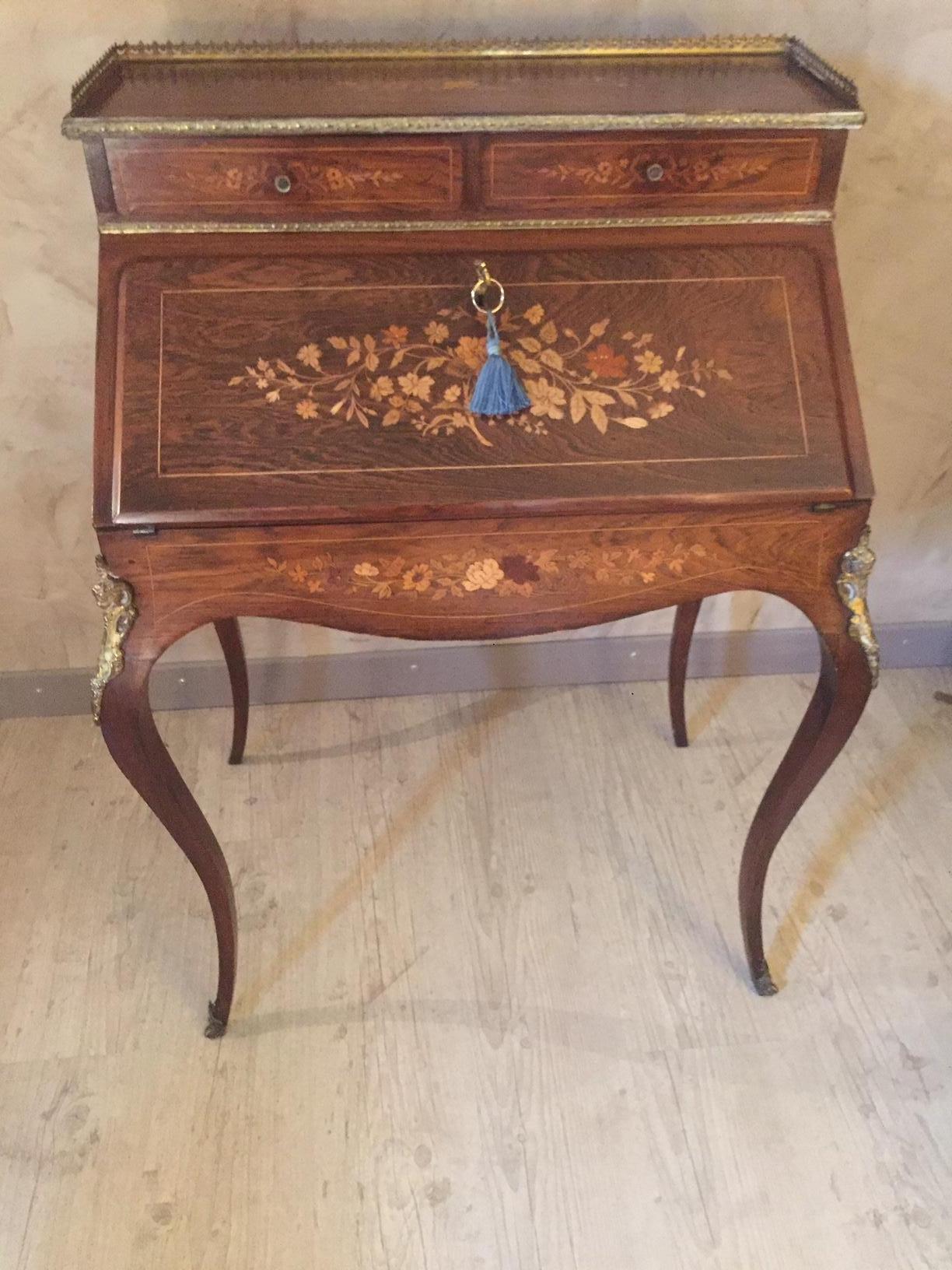 Very nice early 20th century French Louis XV style opening rosewood inlaid Secretaire.
Beautiful Flower marquetry. 
Original angel's head bronze. 
Bronze gallery. Original key. Two outside drawers. Inside, multiple drawers. 
The writing part