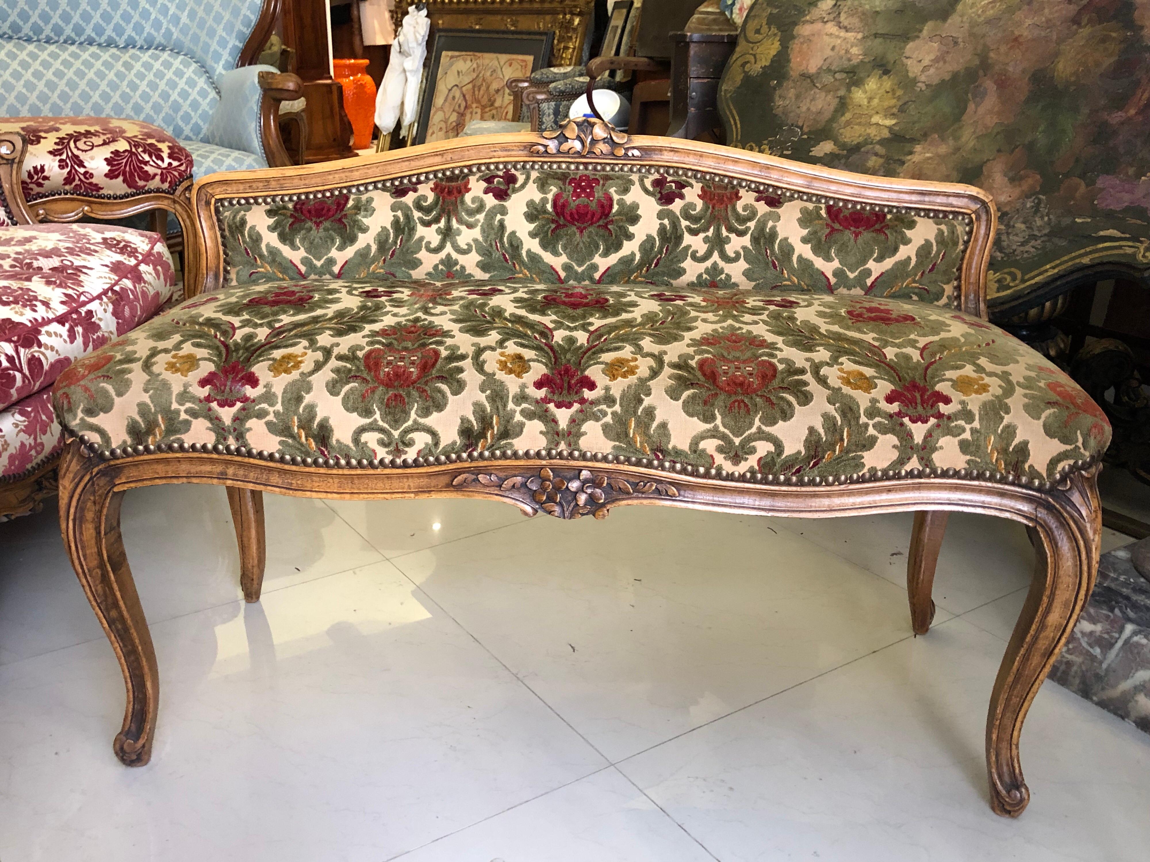 Elegant and very comfortable hand carved walnut piano bench for two.
Recently upholstered in floral green and red textile. Very good condition.
France, circa 1920.
    