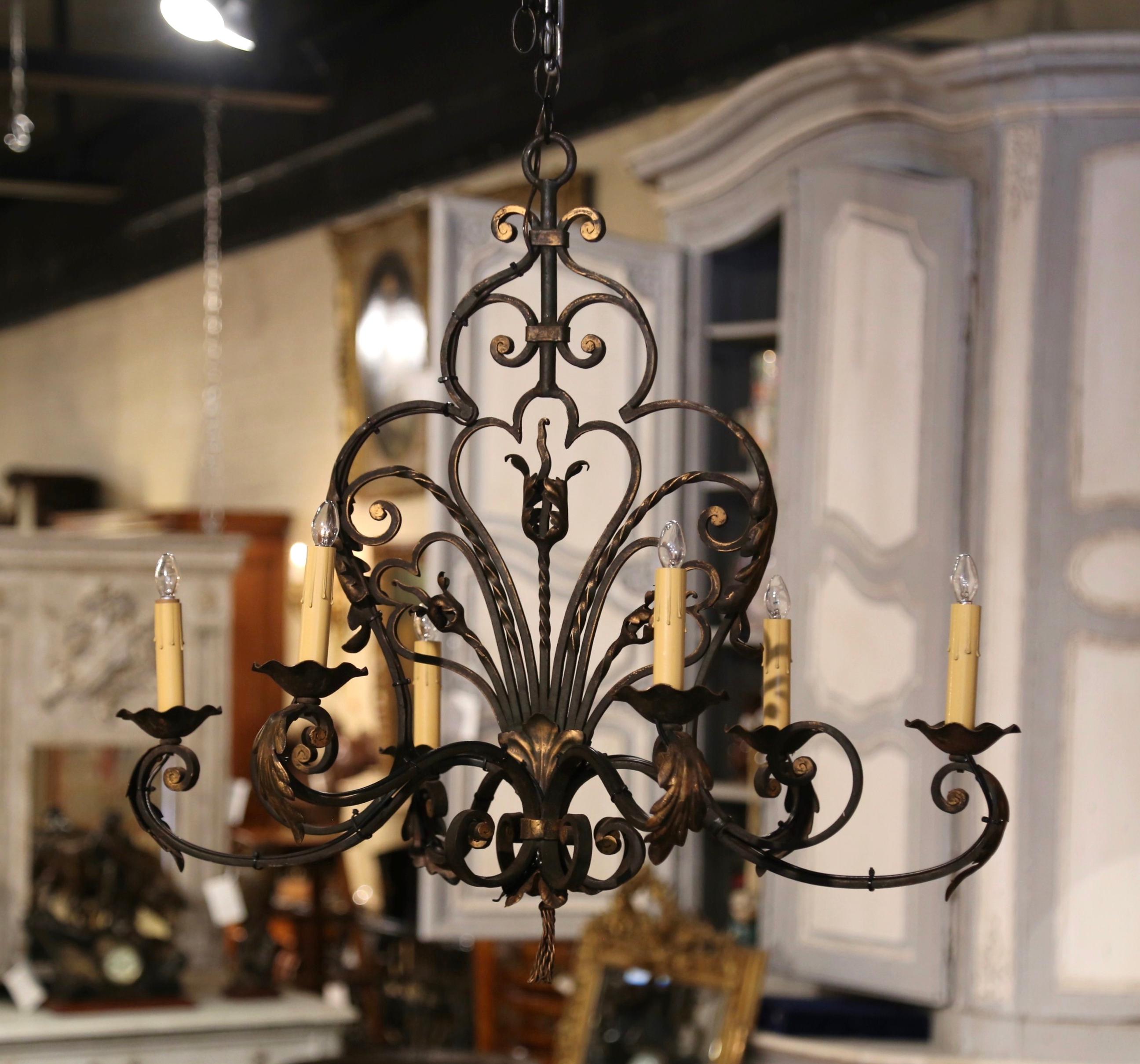 This elegant chandelier would make a lovely addition to a breakfast or dining room. Crafted in France circa 1920, and built of iron, the chandelier is oblong in shape. The fixture is decorated with metal flowers, acanthus leaves and scroll and