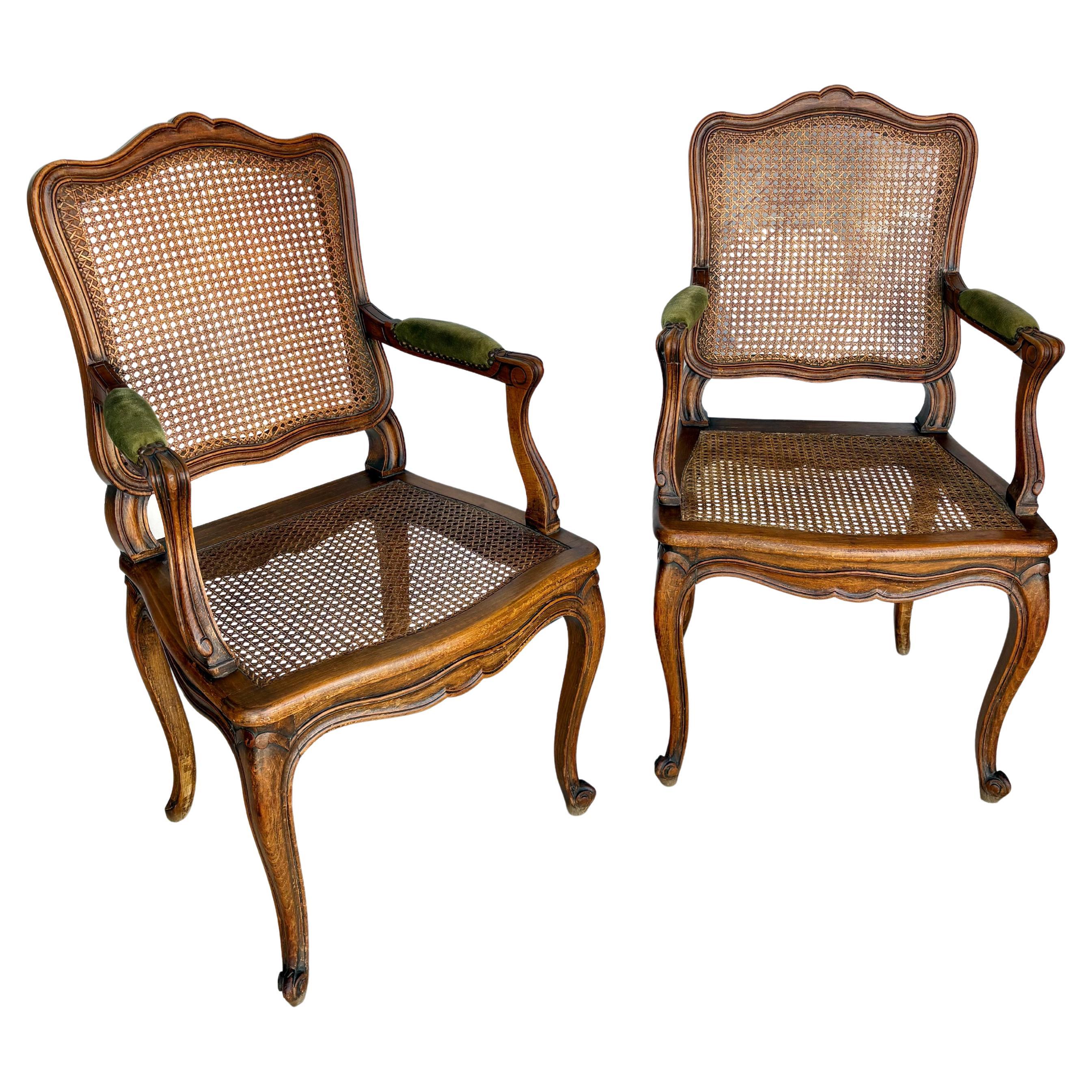 Trouvée dans le sud de la France, cette paire de fauteuils français du début du XXe siècle a été fabriquée à la main à partir de canne et de noyer au début des années 1900. Les chaises sont dotées d'un cadre en noyer, d'une assise cannelée et d'un
