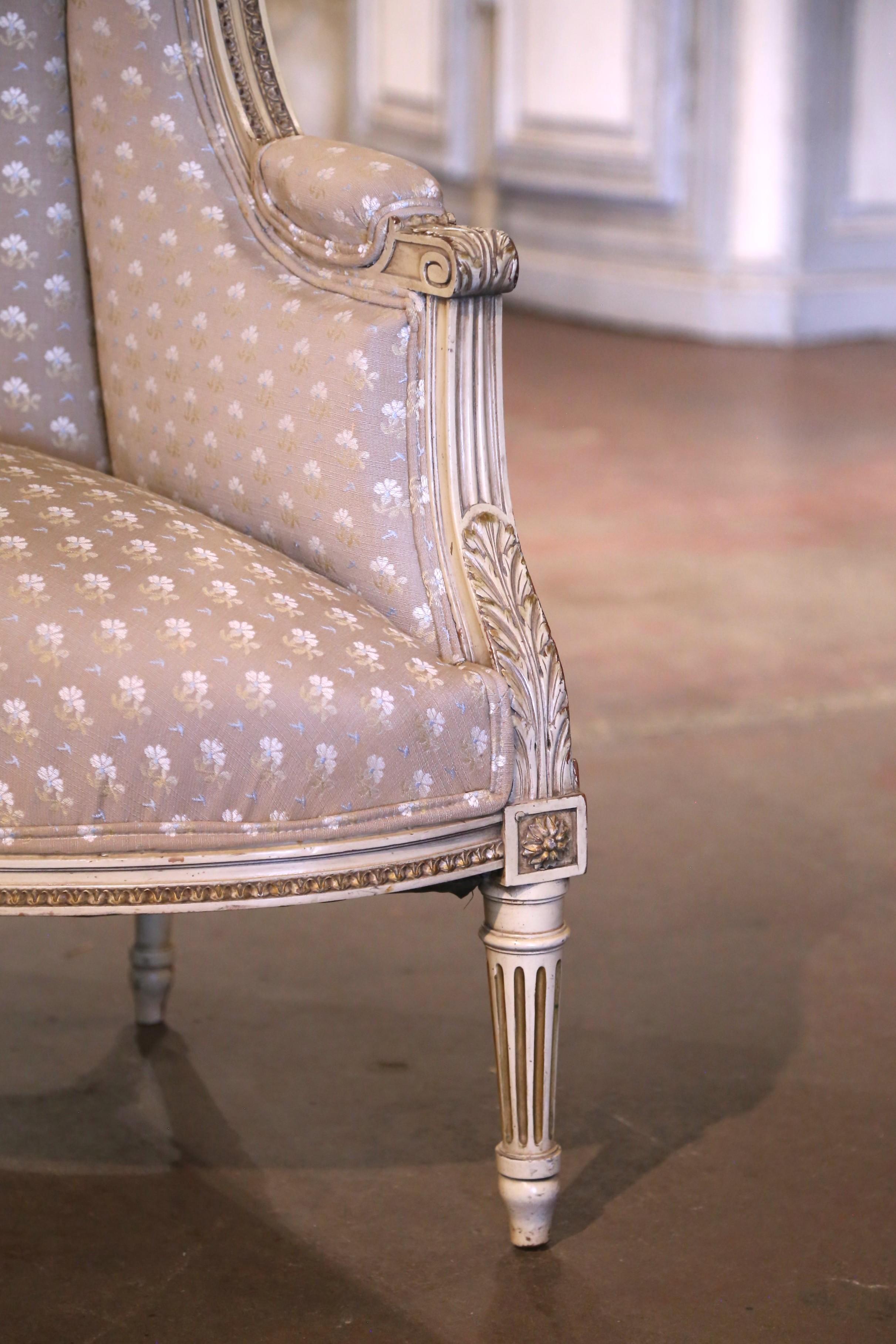Enhance a study, office, or elegant corner with this exquisite antique corner bergère. Handcrafted in France circa 1920, this unique wing back chair is designed in the Louis XVI style and features a rare curved silhouette that fits seamlessly into a