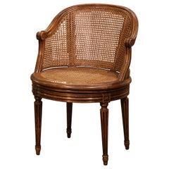 Early 20th Century French Louis XVI Carved Walnut and Cane Swivel Desk Armchair
