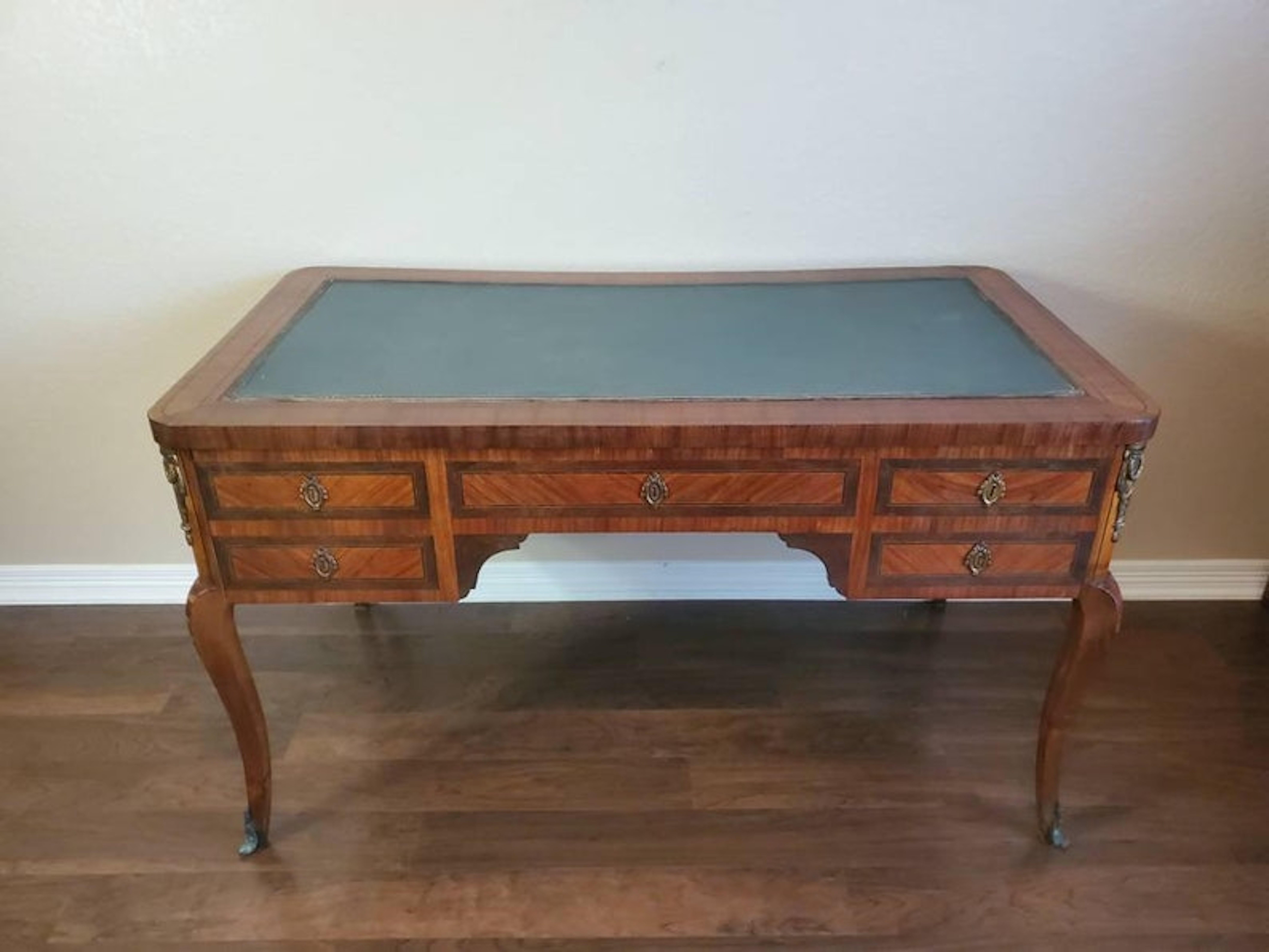 Un antico scrittoio in stile Luigi XVI con una bella patina. Realizzato a mano in Francia all'inizio del XX secolo, presenta una ricca finitura in mogano ornata da inserti in bronzo dorato o ormolu, un piano rettangolare con superficie di scrittura