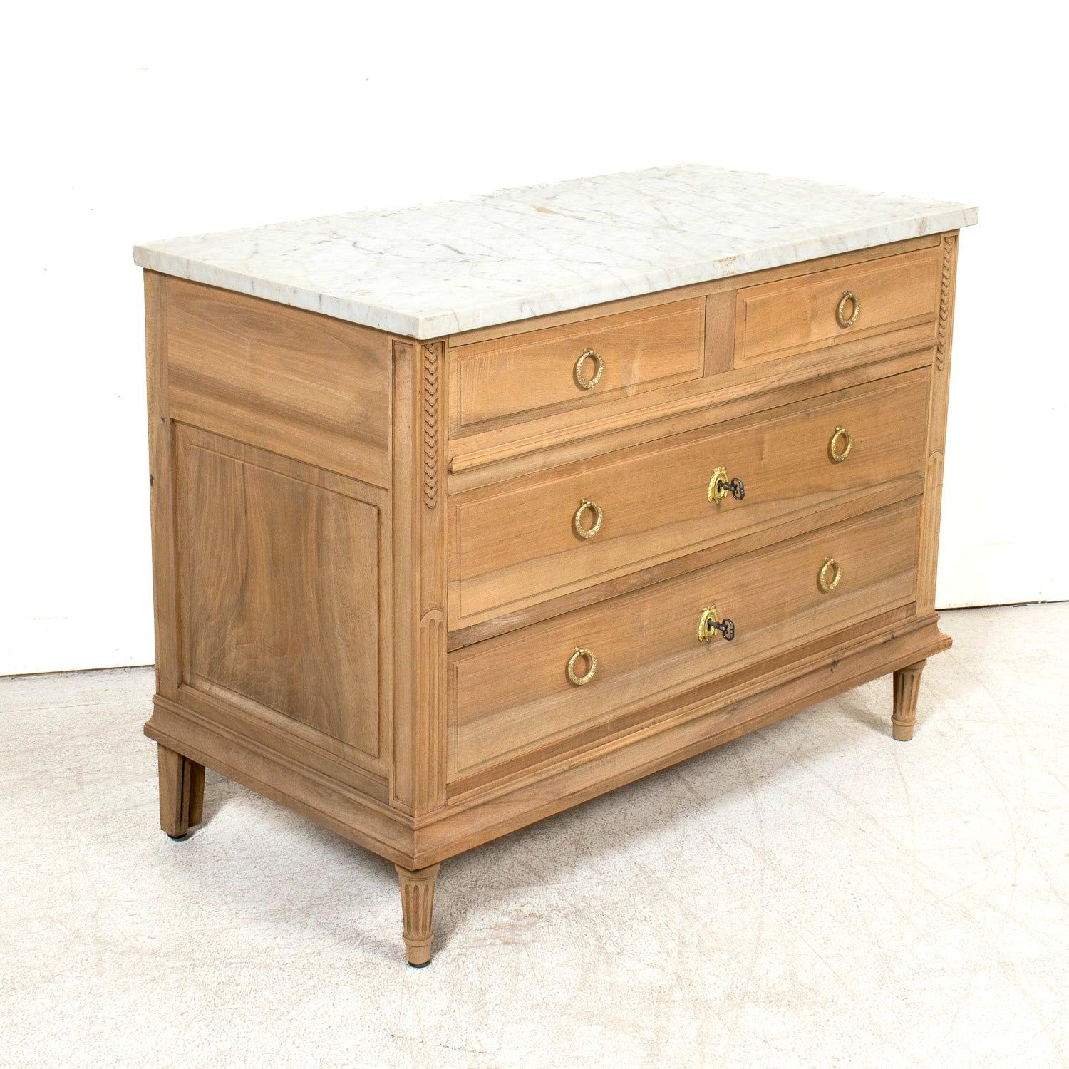 A striking early 20th century French Louis XVI style commode, handcrafted from walnut by skilled artisans in Narbonne, an historic medieval city in the Occitanie region of southern France, circa 1910. Featuring a beautifully bleached or washed
