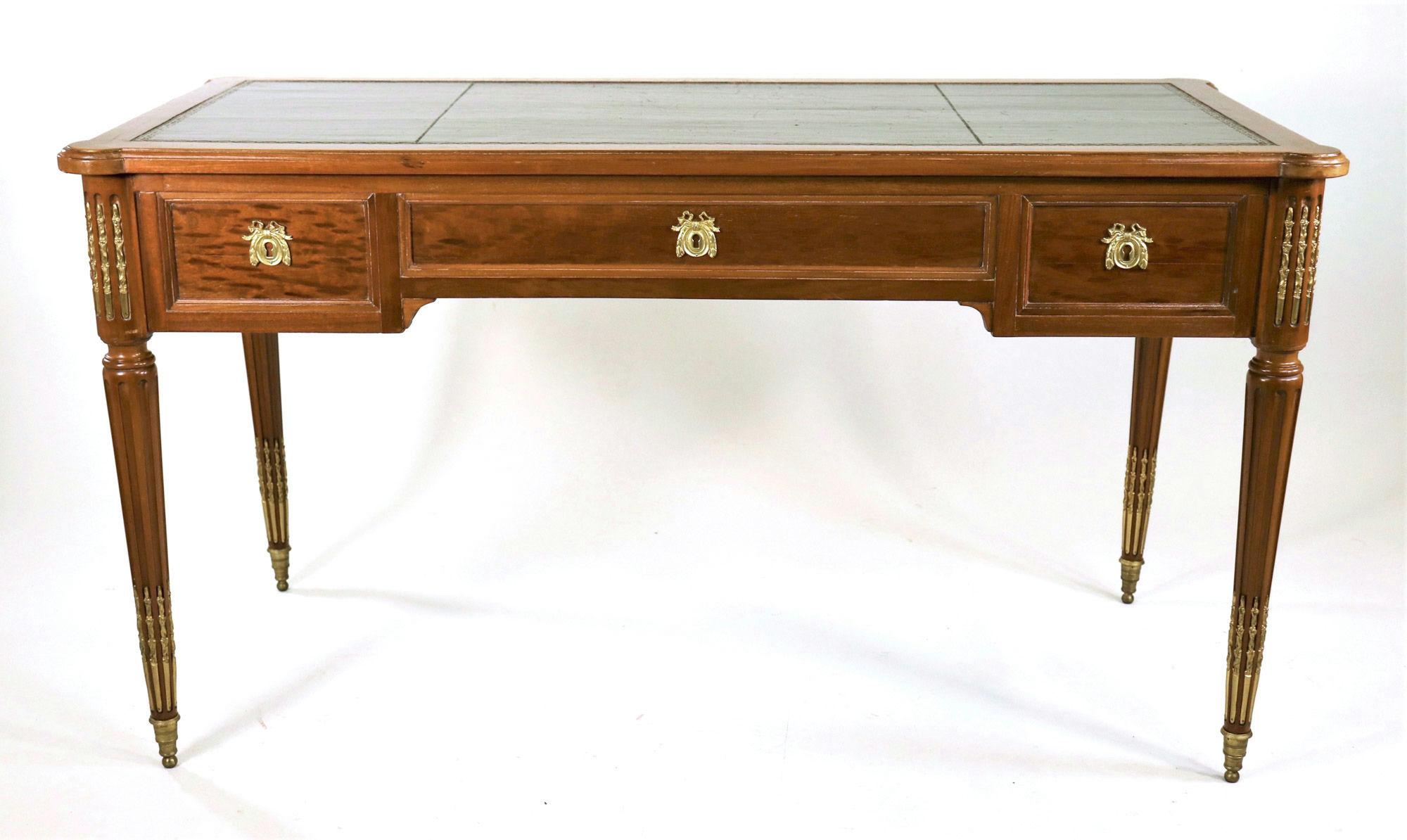 Questo squisito tavolo da bureau in stile Luigi XVI, risalente al 1900, esemplifica la raffinata maestria e l'elegante design caratteristici dell'epoca. La scrivania è costruita meticolosamente con un'impiallacciatura di mogano, che presenta una