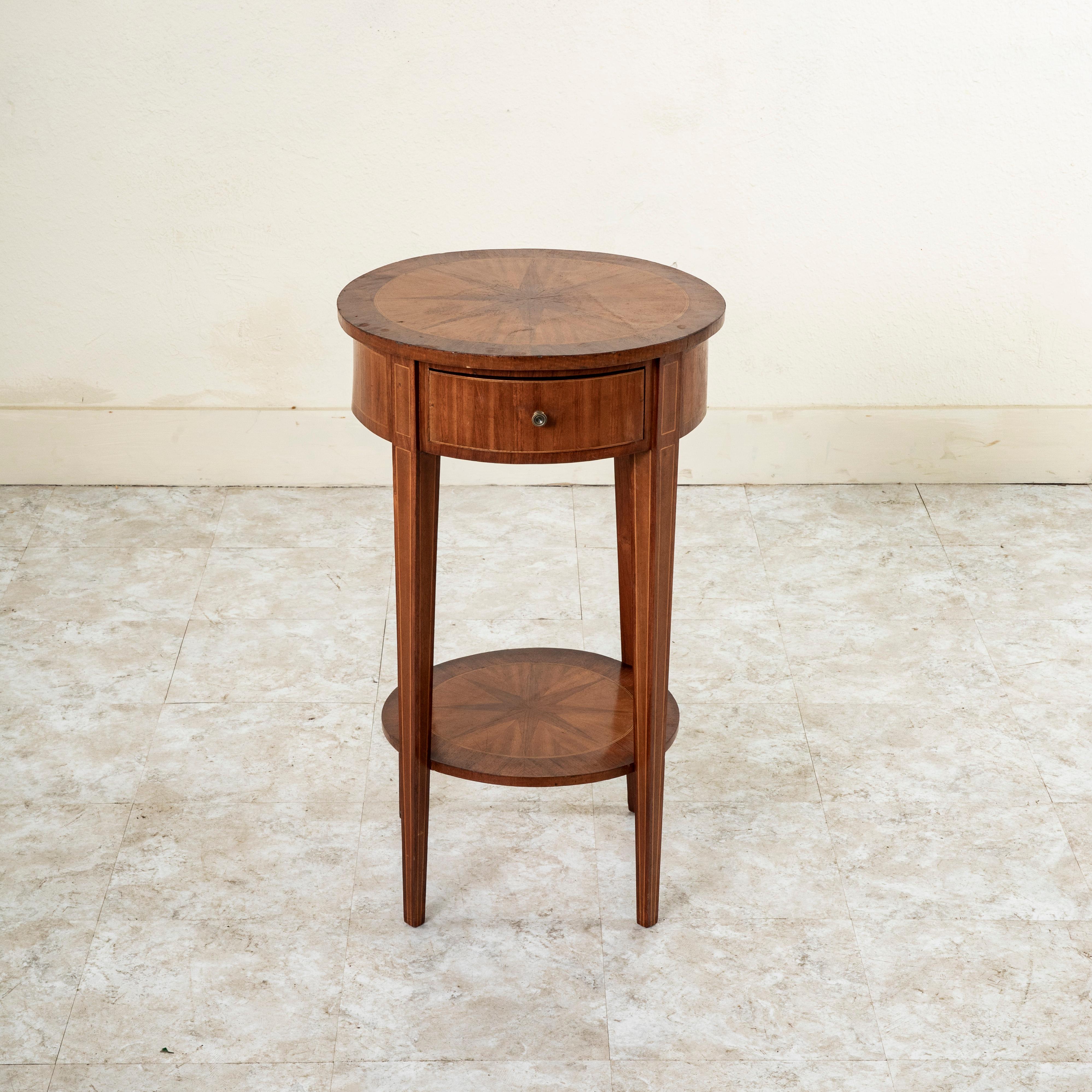 This early twentieth century French Louis XVI style rosewood side table features an inlaid eight pointed rosewood star in a circle of walnut surrounded by a fine border of lemonwood on the top. The table rests on four tapered square legs with an