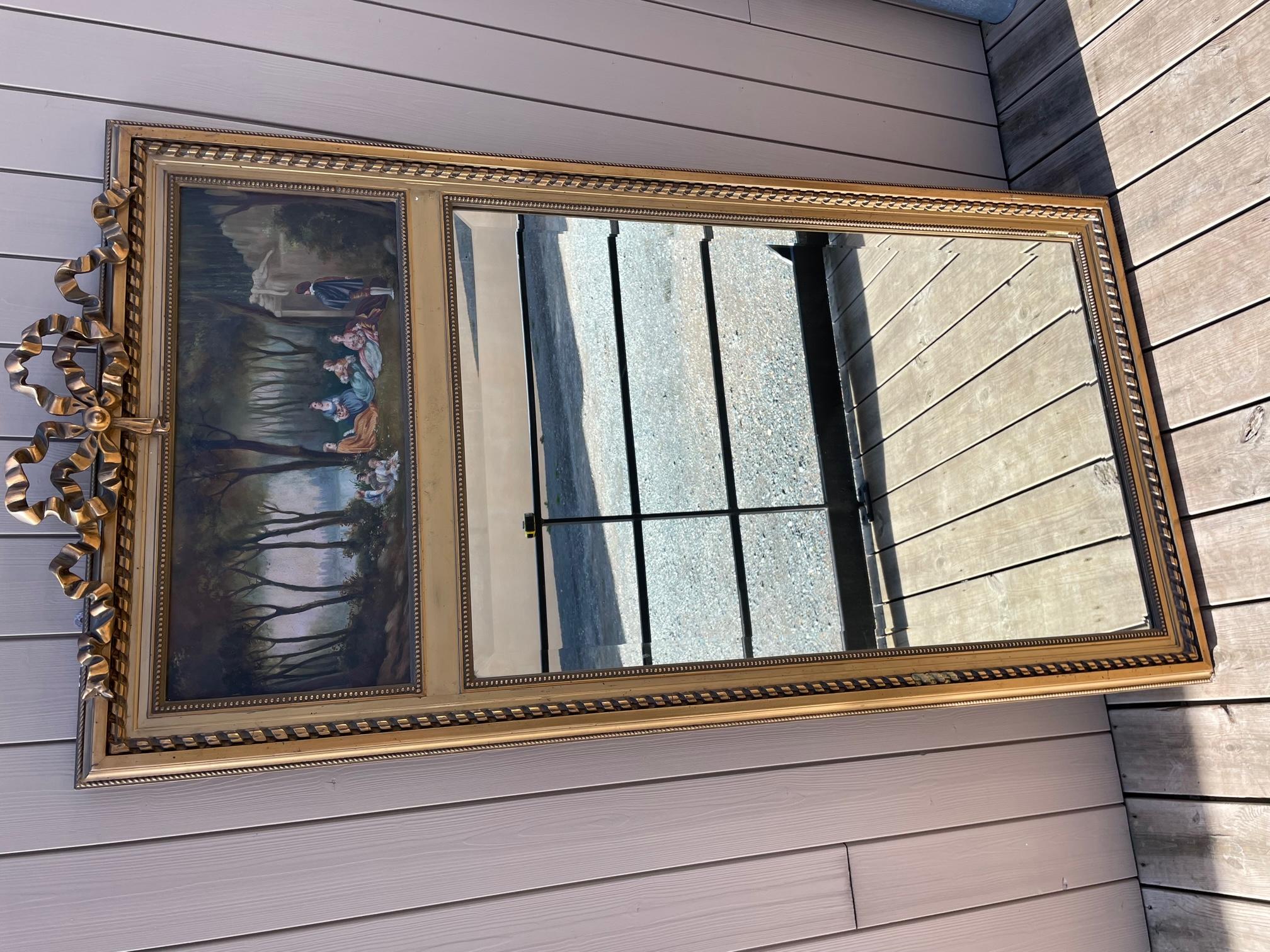 Französischer Trumeau-Spiegel im Louis-XVI-Stil aus den frühen 1900er Jahren. 
Charmantes Gemälde auf der Spitze des Trumeaus, das Menschen darstellt, die sich im Wald entspannen. 
Abgeschrägter Spiegel. Der Knoten auf der Oberseite ist typisch für