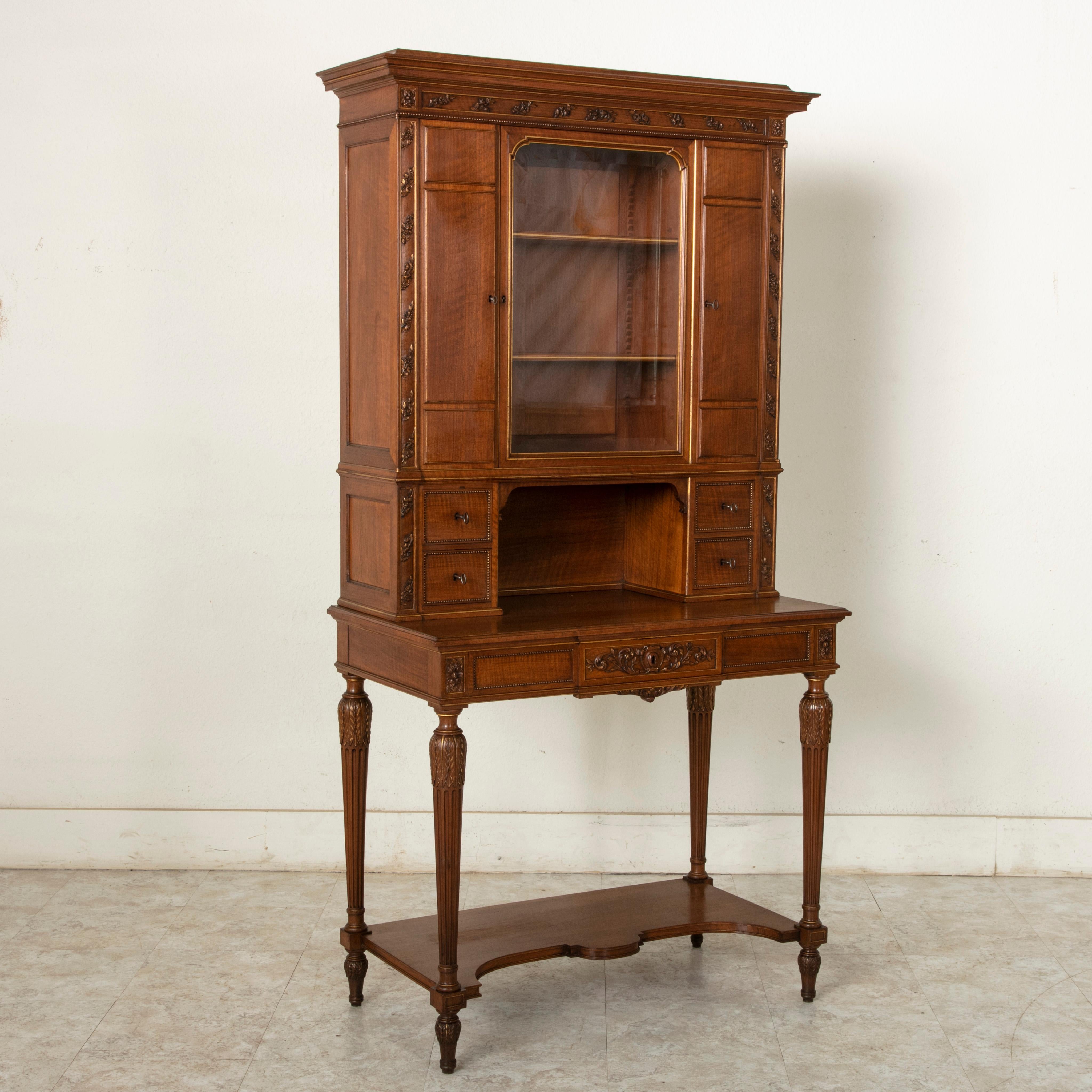 Referred to as a Bonheur Du Jour, or 'daytime delight', this early 20th century walnut secretary writing desk with gold detailing is from the city of Lyon, France. Its lower writing table surface features rosettes at the corners and tapered fluted