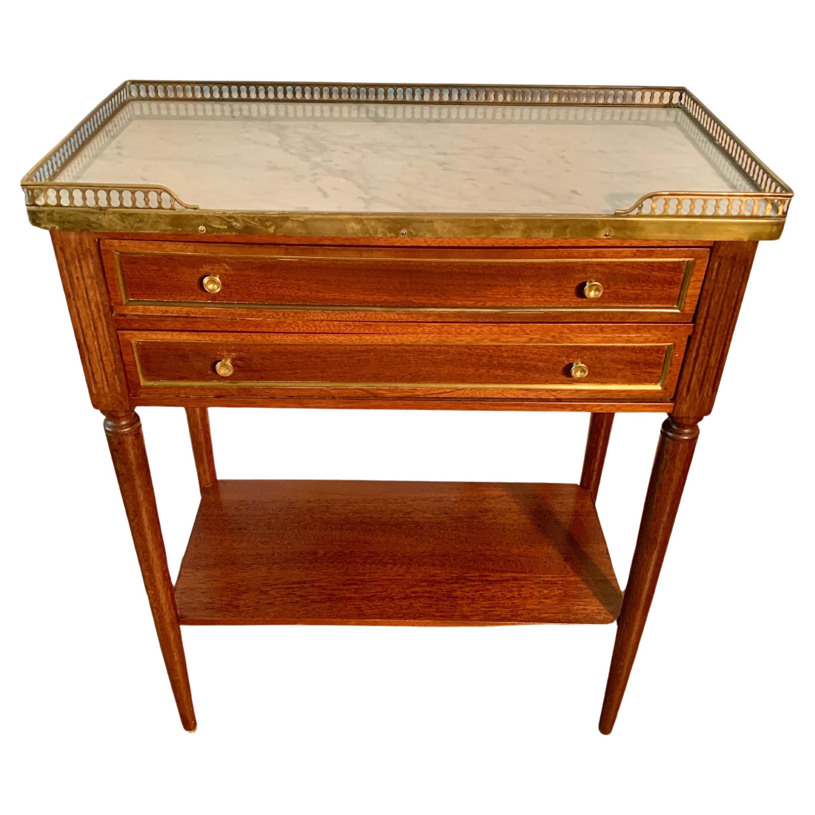 Trouvée dans le sud de la France, cette table d'appoint française du début du XXe siècle a été fabriquée au début des années 1900 à partir de noyer, de marbre et de laiton dans le style Louis XVI. La pièce présente un plateau en marbre blanc veiné,