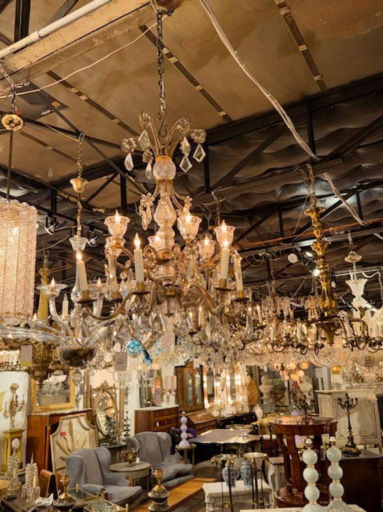 This is an early 20th-century French Maison Bagues chandelier made of gilt bronze and crystal. The chandelier features a luxurious design typical of French style, with intricate craftsmanship and detailing. The use of bronze and crystal adds a touch