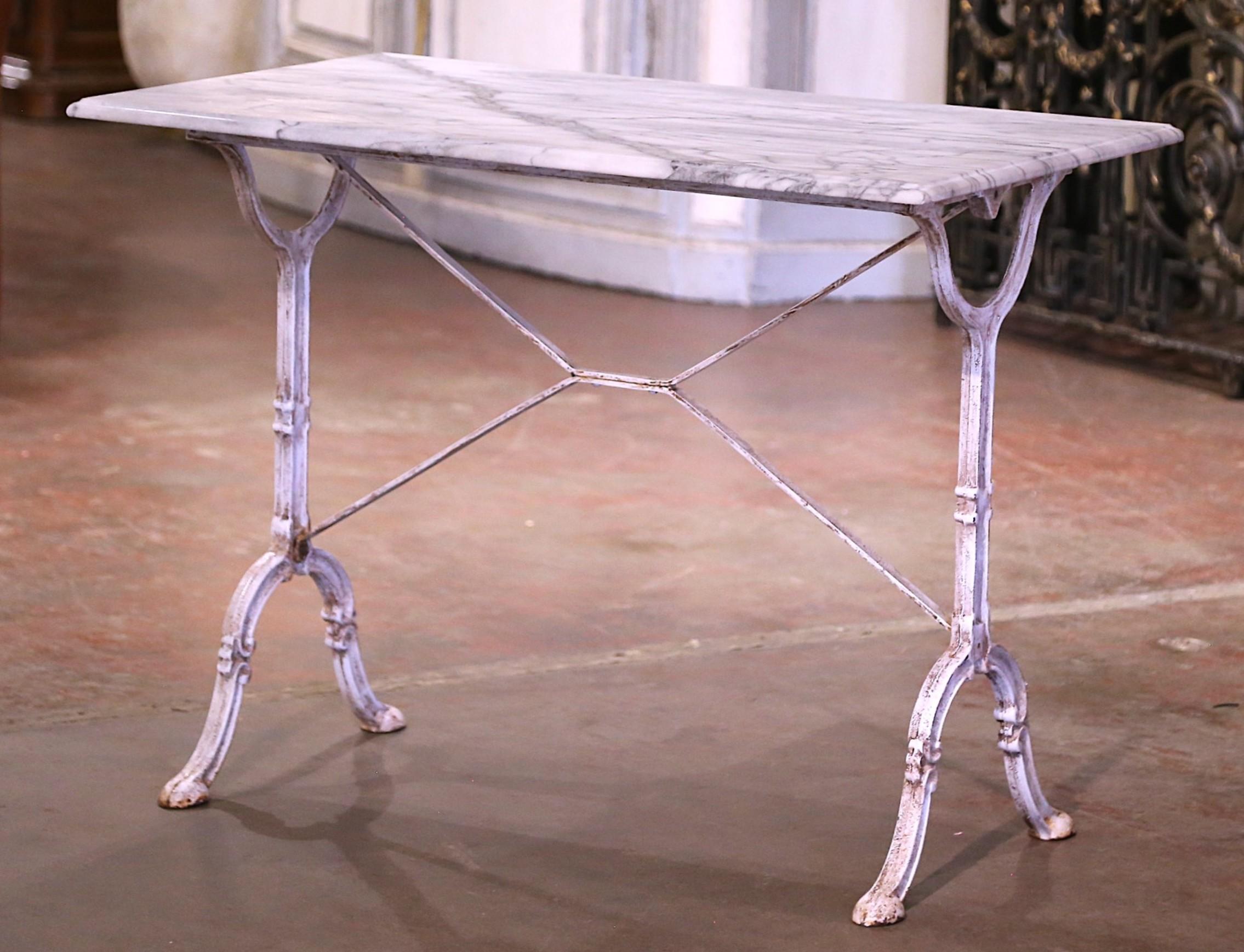 Faites entrer la beauté de Paris dans votre maison avec cette table à pâtisserie antique sophistiquée. Fabriquée en France vers 1930, la table antique repose sur une base à tréteaux en fonte avec d'élégants pieds à volutes se terminant par des pieds