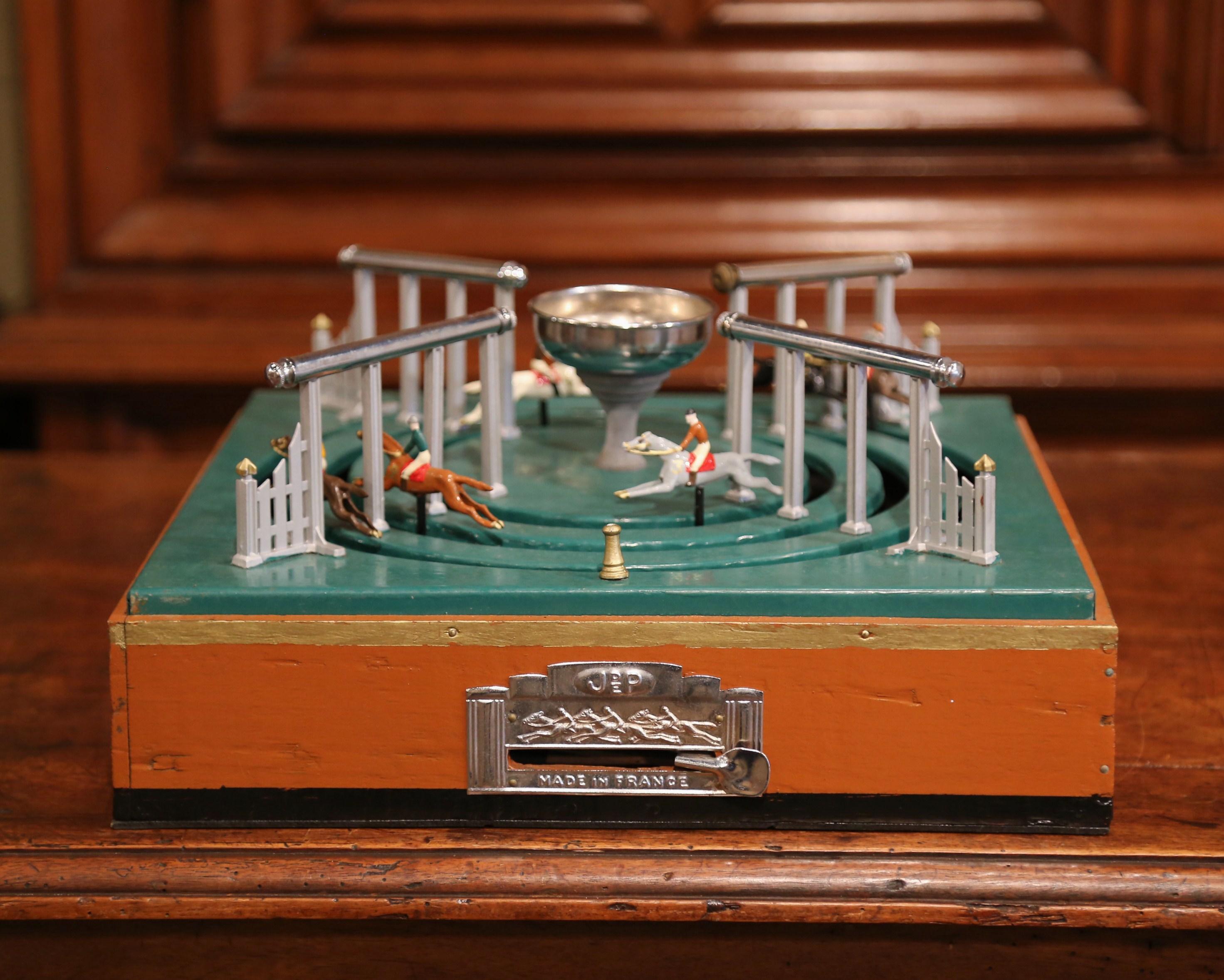 Entertain your friends with this antique automaton horse racing gambling game. Crafted in France, circa 1920, the mechanical game is played by moving the lever so the horses run around the track. At the same time, the players gamble and put money in