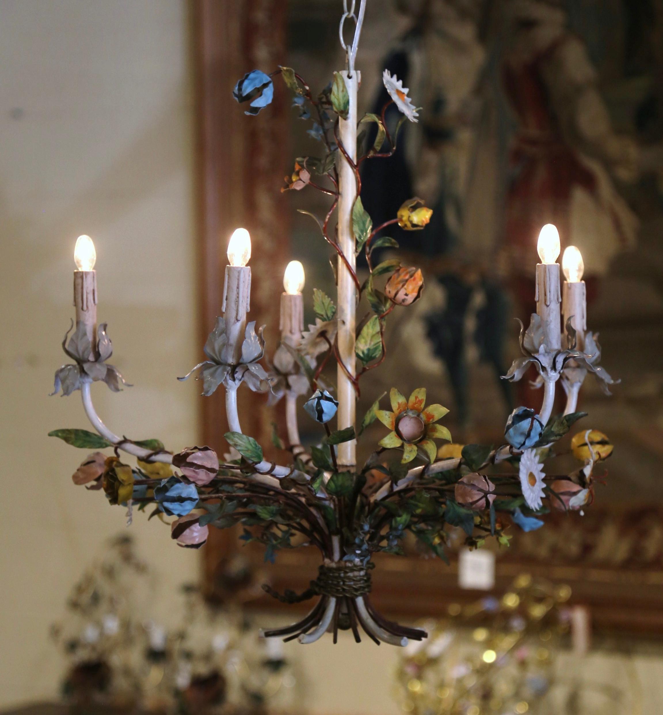 Decorate a girl's room or powder room with this elegant and feminine light fixture. Crafted in France circa 1920, and round in shape, the antique chandelier with a white central frame is decorated with a wide variety of flowers in different shapes