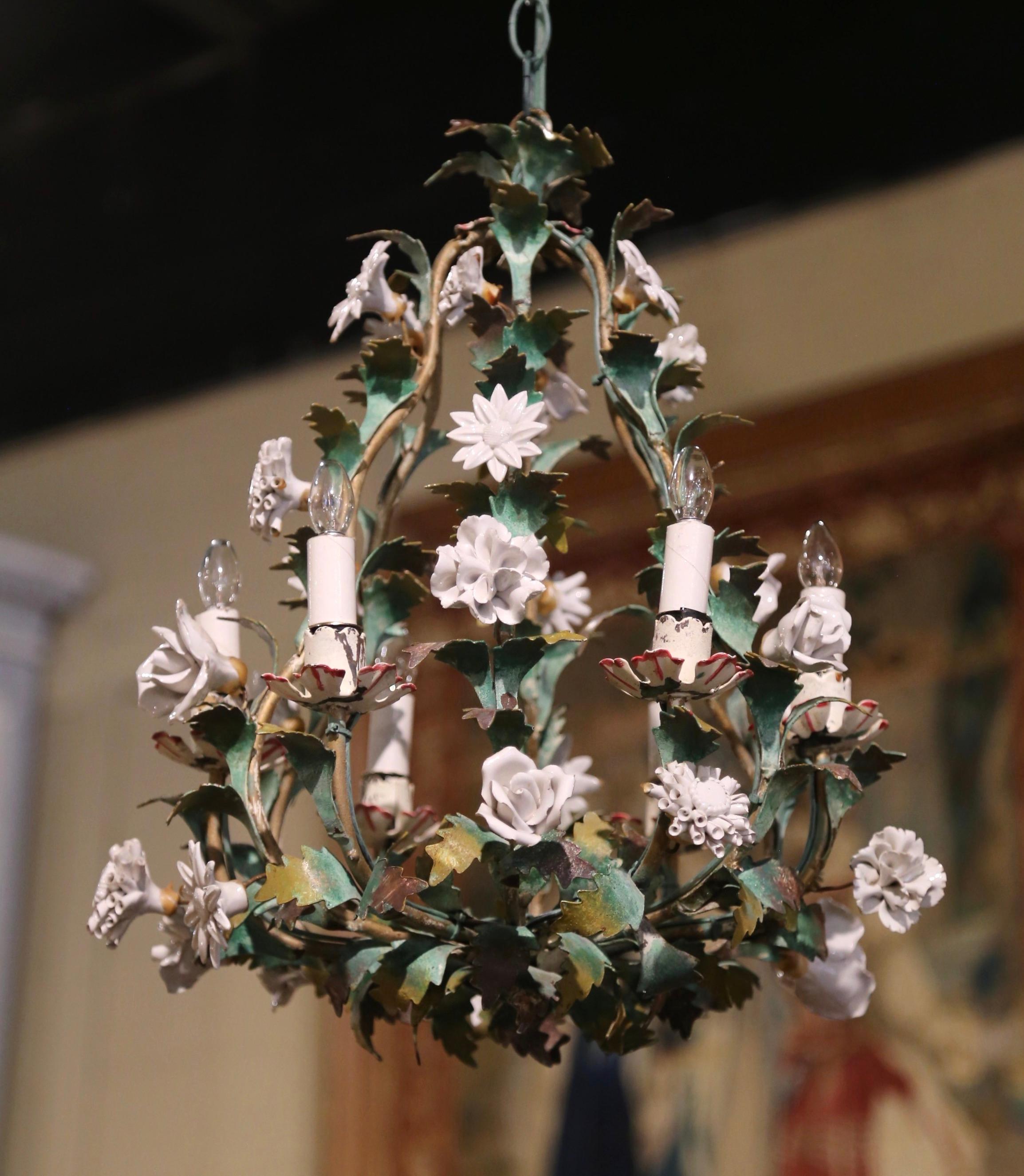 Decorate an entryway or powder room with this elegant and feminine light fixture. Crafted in France circa 1920, the petite antique chandelier is decorated with white and light pink porcelain flowers surrounded by painted green leaves. The six-light