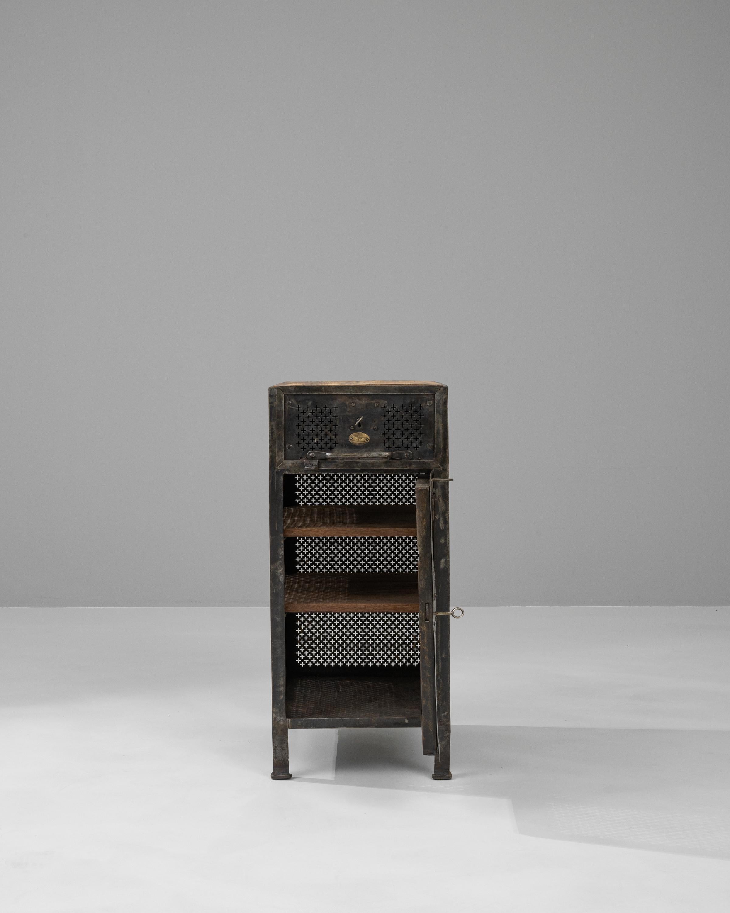 Dieser Nachttisch aus französischem Metall des frühen 20. Jahrhunderts verleiht der klassischen Schlafzimmereinrichtung einen industriellen Touch. Die Kombination aus robustem, mit verschlungenen Mustern gestanztem Metall und einer warmen Holzplatte