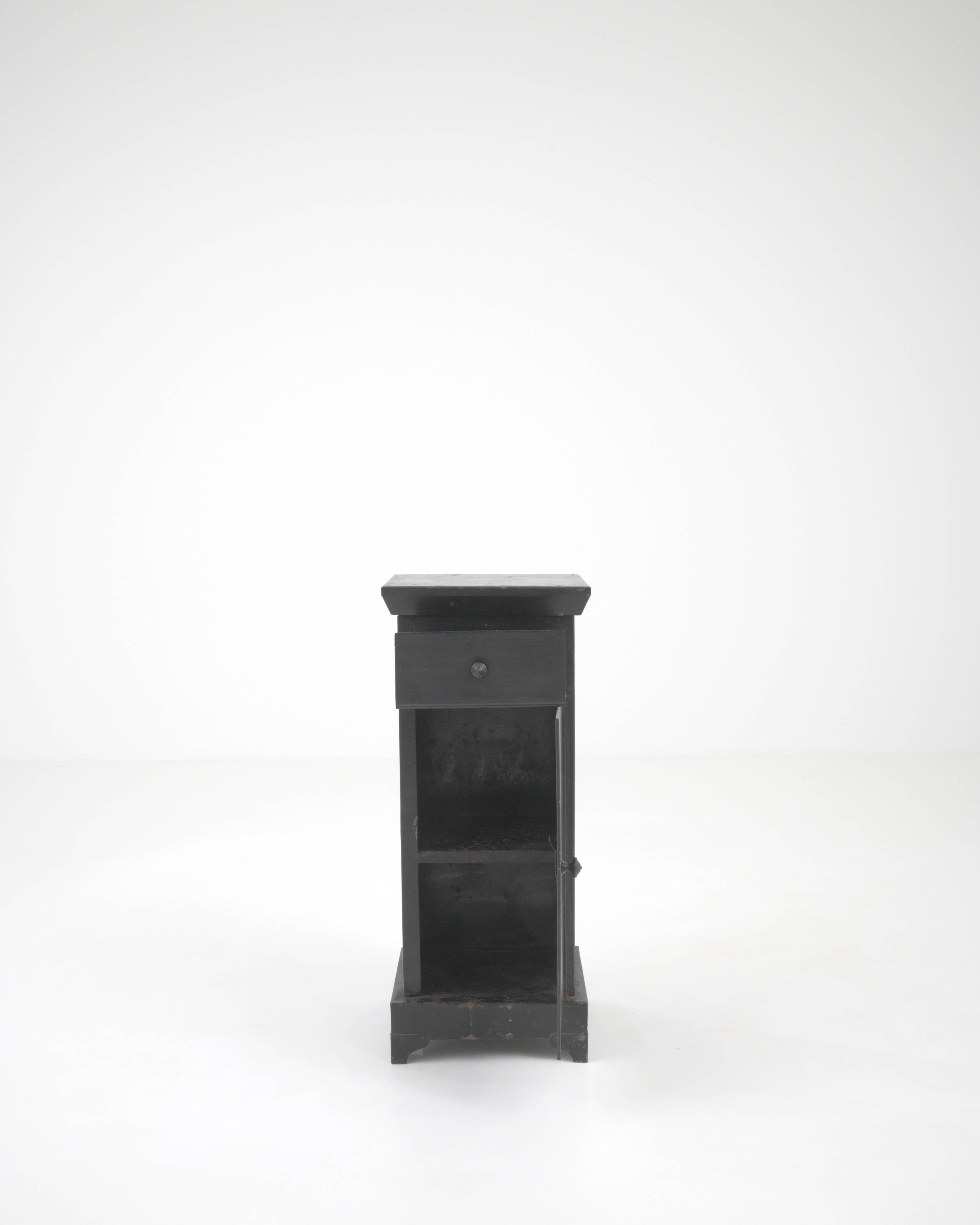 This early 20th-century French metal side table exudes an industrial charm coupled with minimalist elegance. The sleek, dark metal construction provides a sturdy and durable frame, while the subtle patina and wear suggest a storied past. A compact