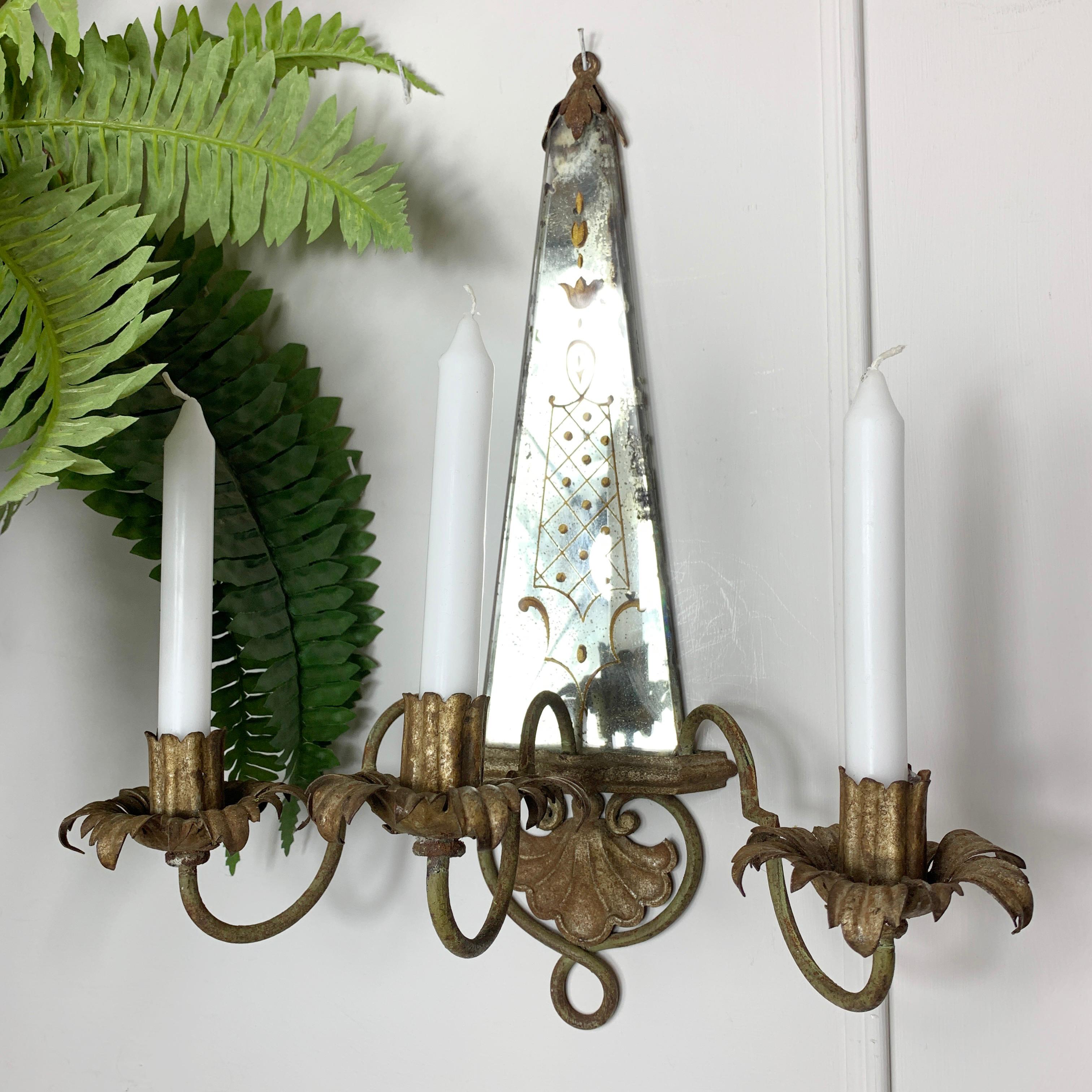 Beautiful back painted mirrored candle wall sconce, dating to the late 19th / early 20th century. French, of very good proportions, the three candle holders in wrought iron, the decorated mirror creates a wonderful effect when the flames reflect