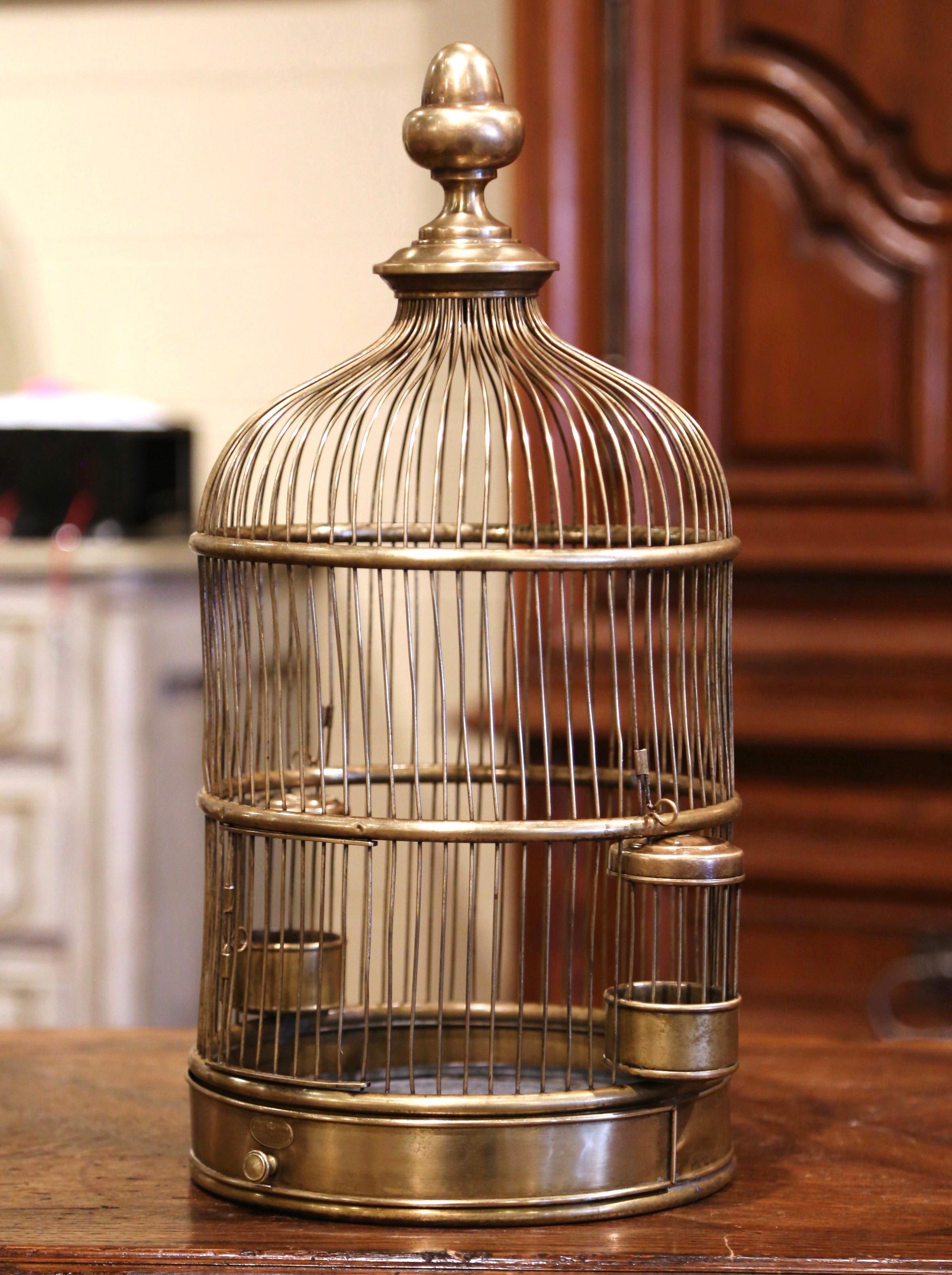 Decorate your home with this whimsical antique bird cage. Crafted in the Alsace Lorraine region of France, circa 1920, this Napoleon III cage made of brass, is cylindrical in shape and topped with a rounded dome embellished with a decorative finial.