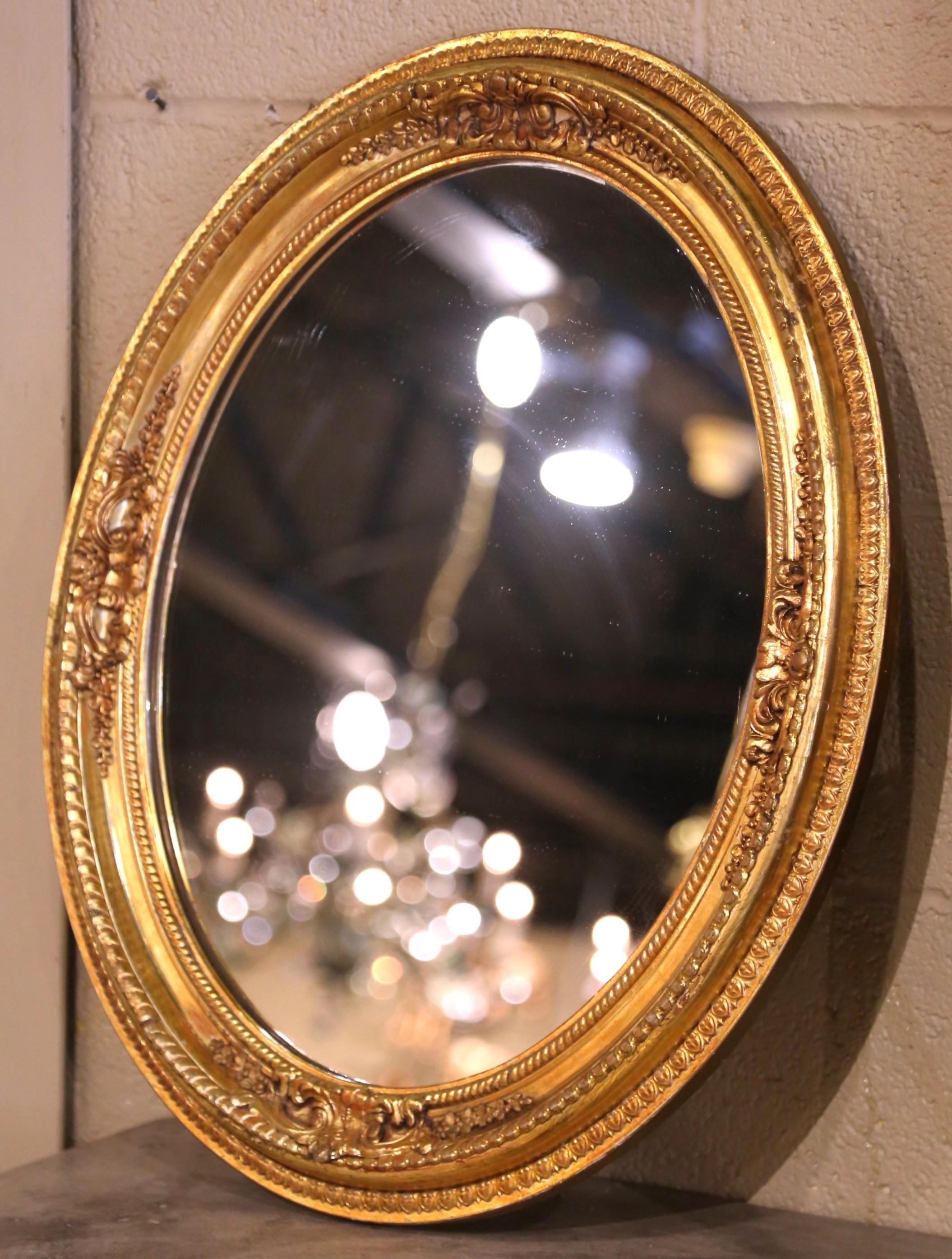 
Vesti una parete con questo elegante specchio ovale antico. Realizzato in Francia intorno al 1920, lo specchio presenta una cornice riccamente scolpita con intricati motivi floreali e fogliati in alto rilievo. La cornice in legno intagliato è