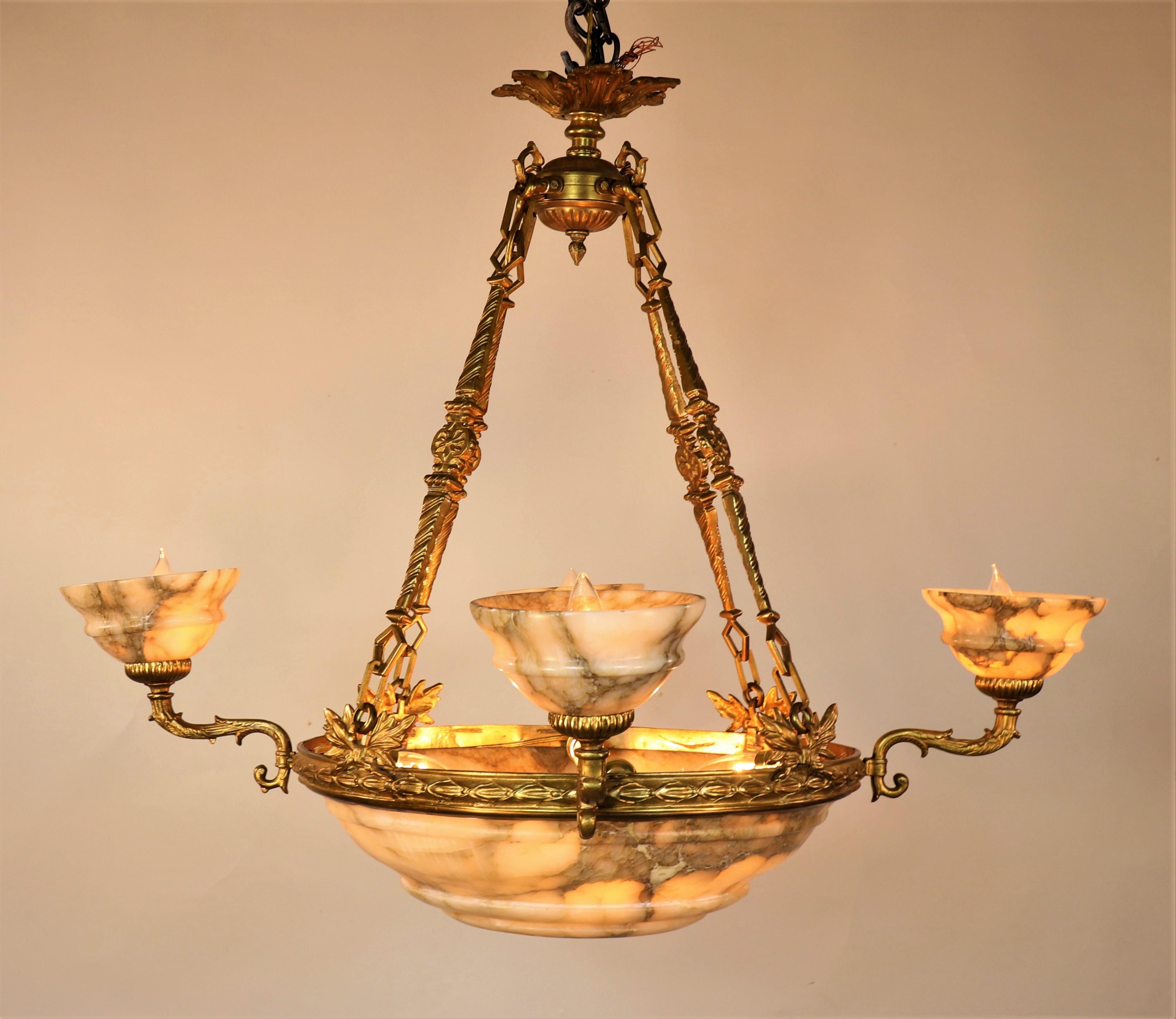 Questo lampadario dell'inizio del XX secolo mette in mostra lo stile neoclassico, emerso in Europa all'inizio del XVIII secolo. Questa estetica del design enfatizzava la simmetria e traeva ispirazione dall'antica arte greca e romana.

L'intricata