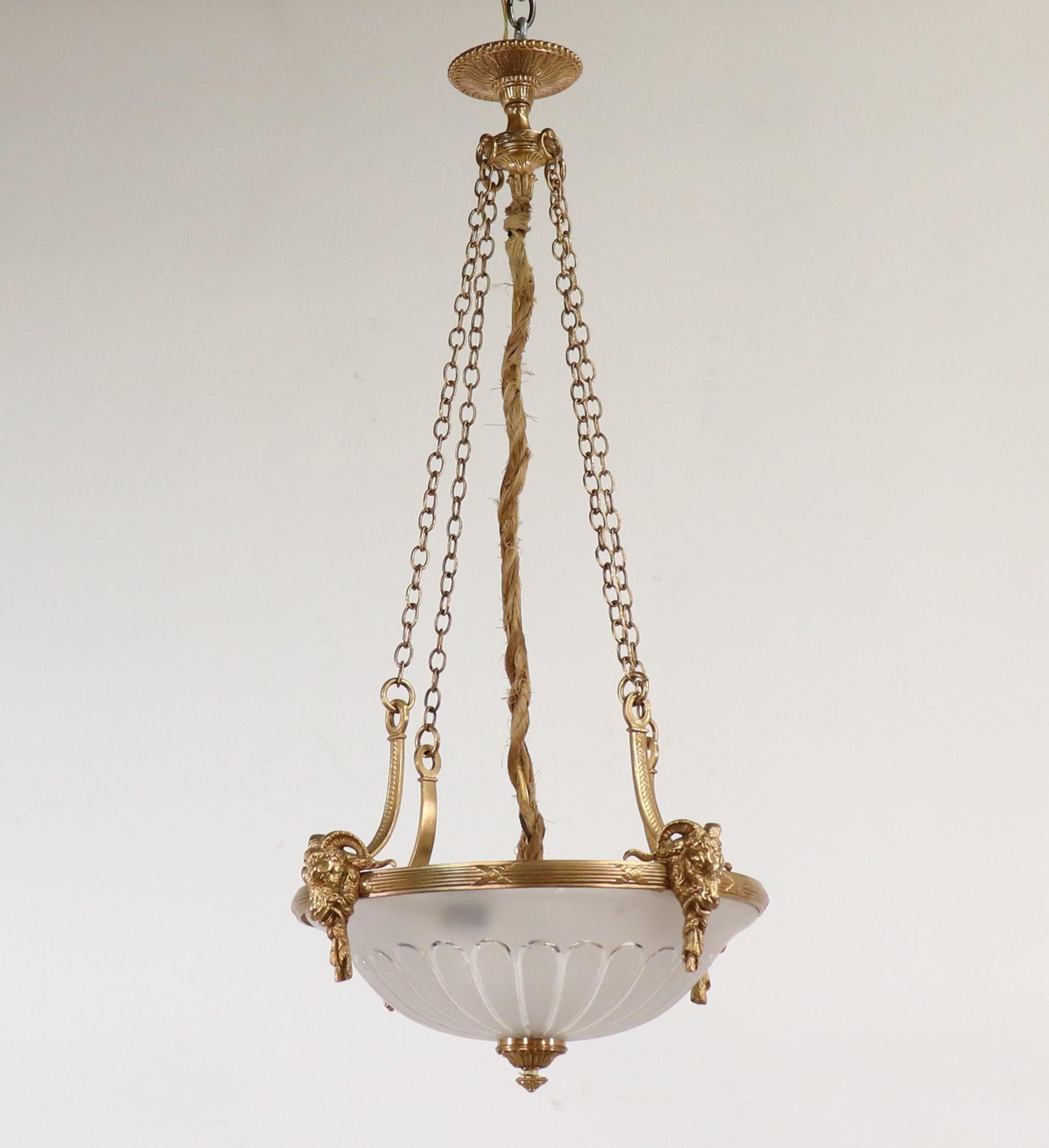 This early 20th-century pendant chandelier was made in the Neoclassical style, which originated in Europe in the early 18th Century. The Neoclassical style was characterized by its symmetry and a return to ancient Greek and Roman motifs. The