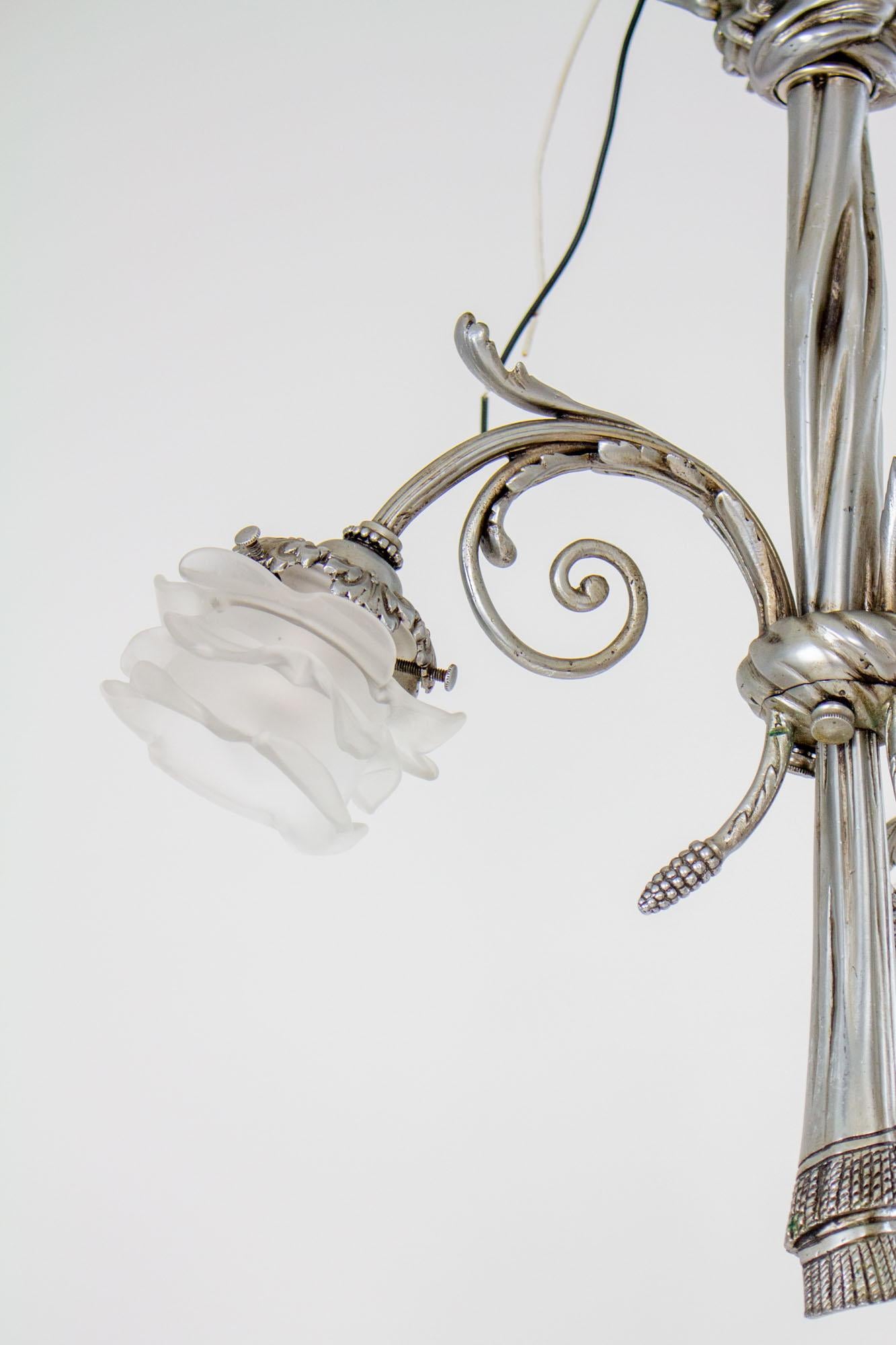 Early 20th Century French Nickel Rose Petal Three Light Chandelier

Three light chandelier, solid brass with original satin nickel plated finish in good condition. Mounts directly to the ceiling with a design of ribbons around the canopy. The
