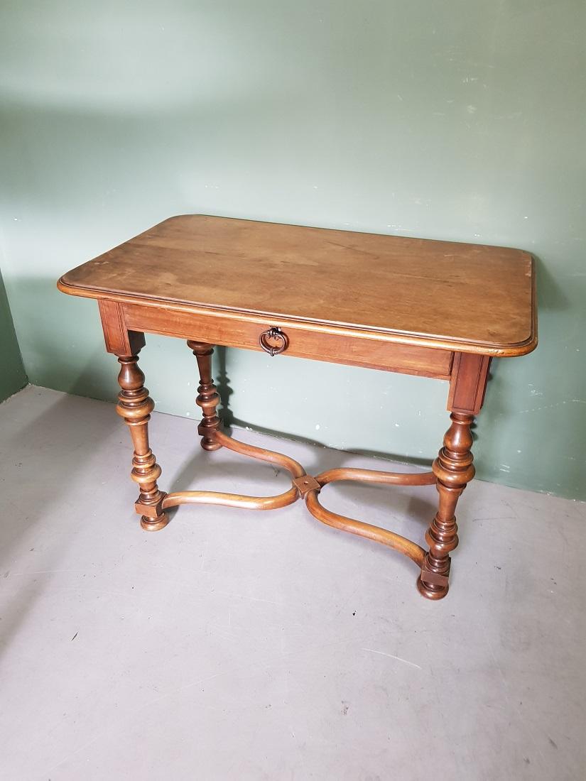 Antique French nutwood veneered table with 1 drawer and solid nutwood base and comes from the well-known firm 