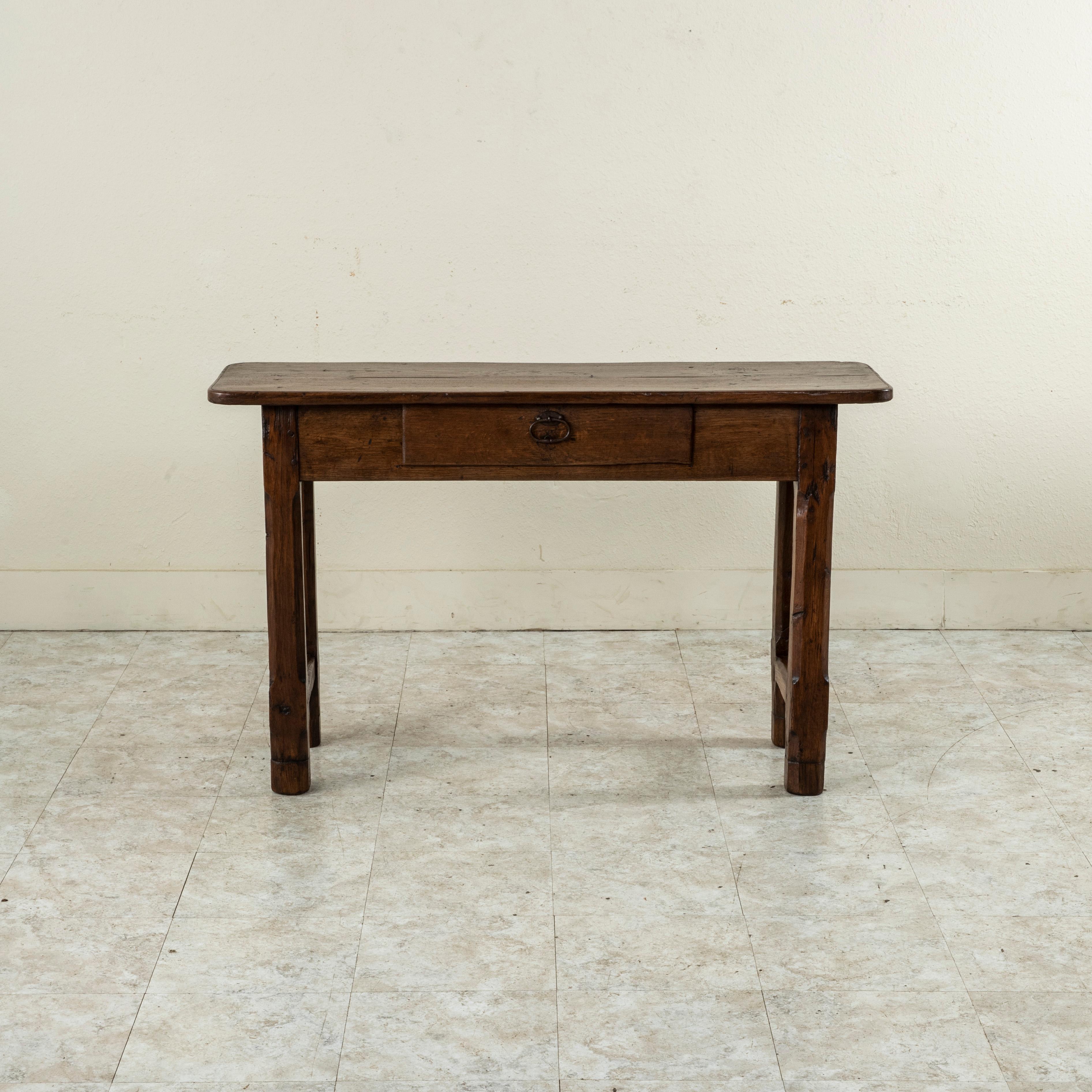 Found in the region of Normandy, France, this oak console table from the turn of the twentieth century features a hand pegged top formed from two planks of wood. A single drawer of dovetail construction fits into the apron and is fitted with an iron
