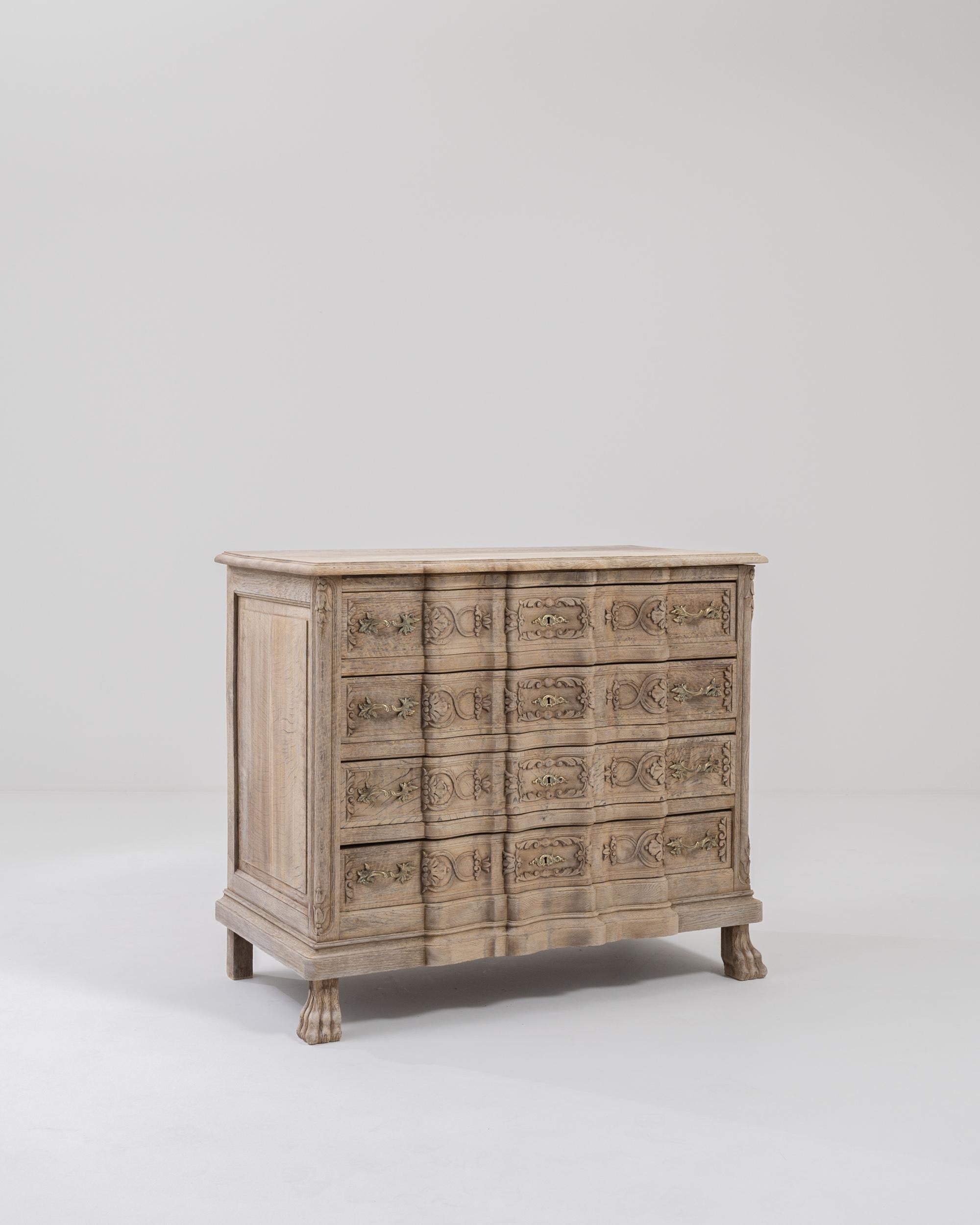 An oak chest of drawers from France, circa 1900. The Baroque styled front of this eye-catching chest of drawers has been elaborately shaped into ripples, which dance across its four front-facing drawers. Scroll patterning weaves across the waves of