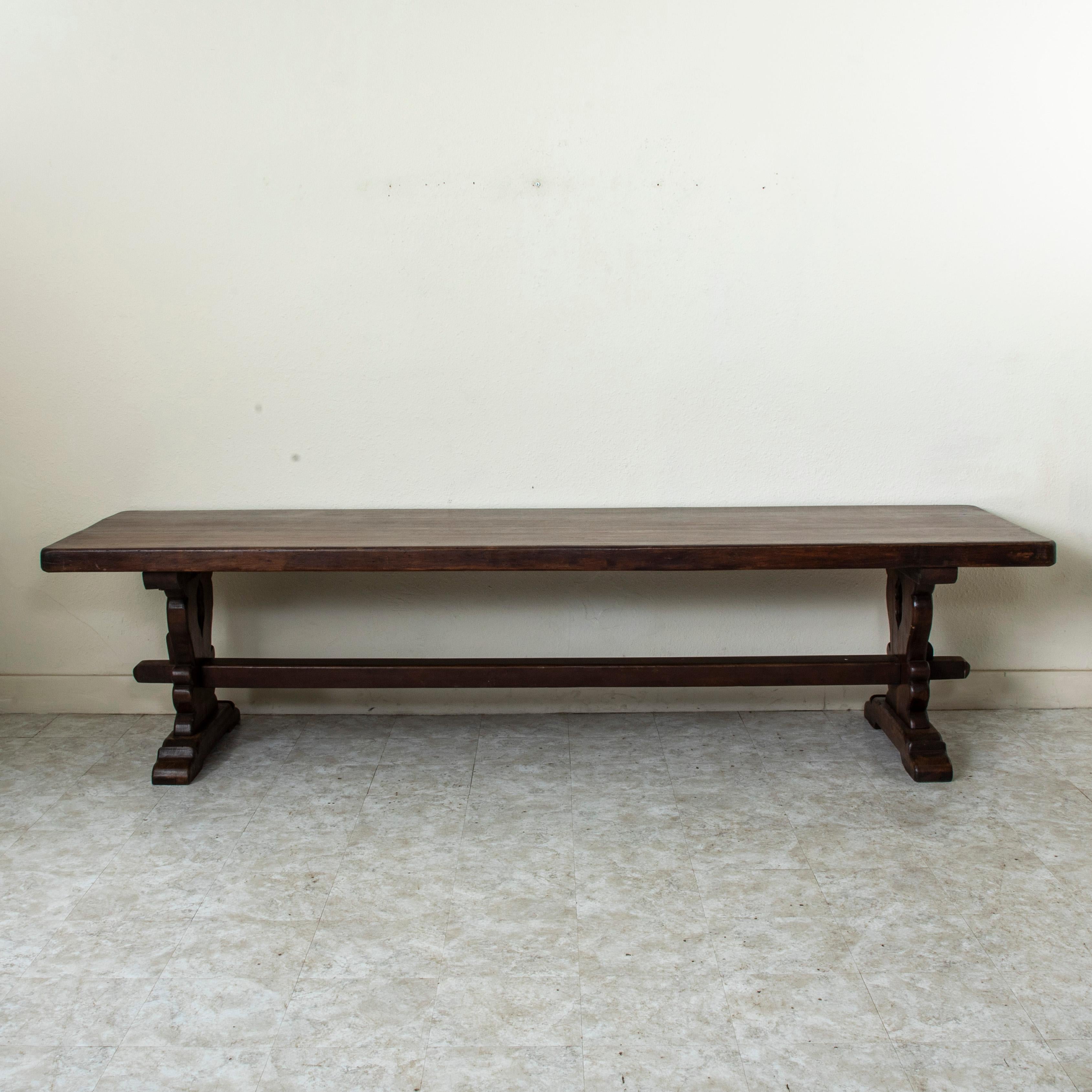 Encontrada en la región de Normandía, Francia, esta gran mesa de monasterio o mesa de comedor de roble hecha a mano a principios del siglo XX presenta un impresionante tablero de 5 cm de grosor construido con tres tablones de madera. La mesa