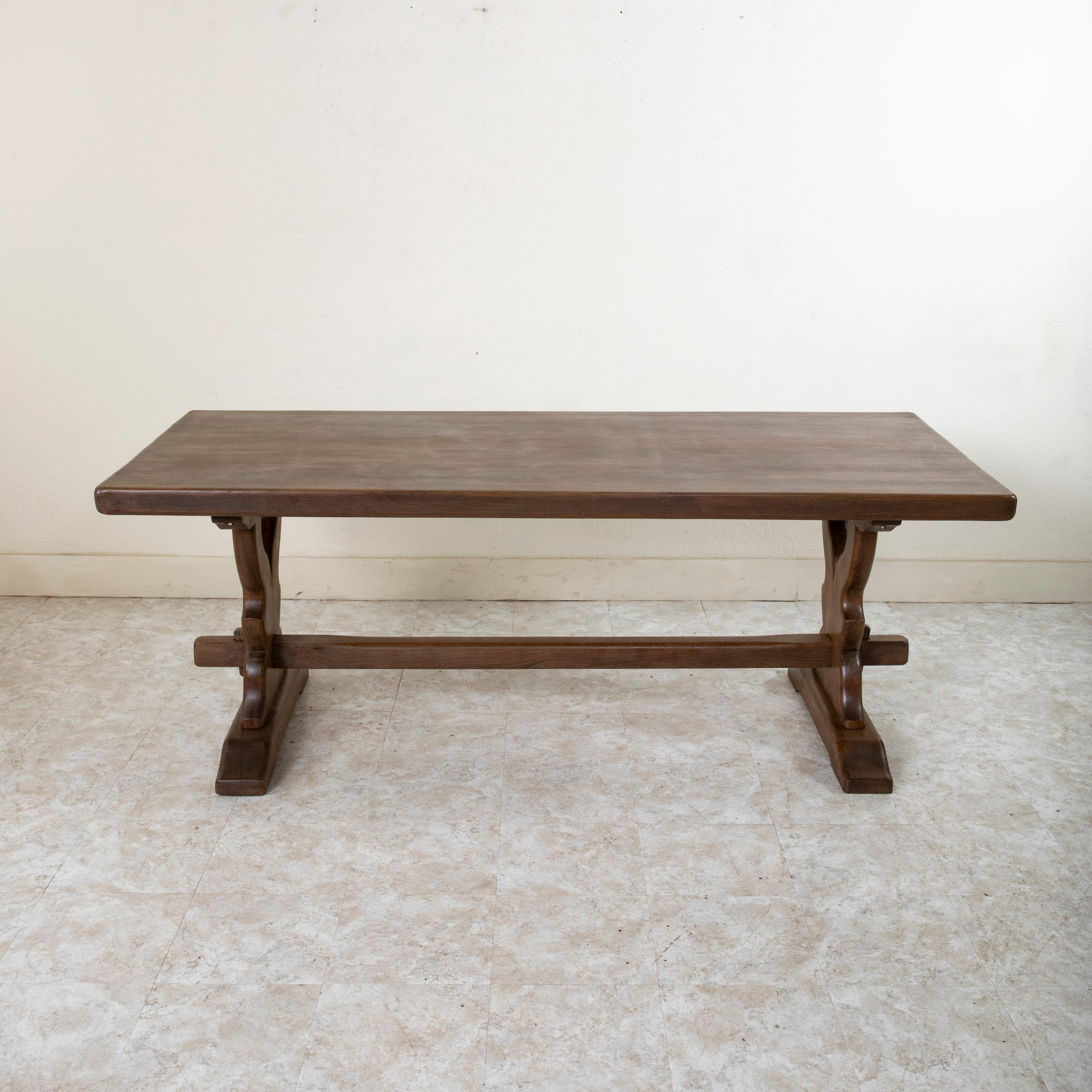 Dieser große, handgefertigte Klostertisch oder Esstisch aus Eiche von der Jahrhundertwende in der Normandie, Frankreich, hat eine beeindruckende, 2,5 Zoll dicke Platte, die aus sieben Holzbrettern besteht. Der Tisch ruht auf einem stabilen Gestell,