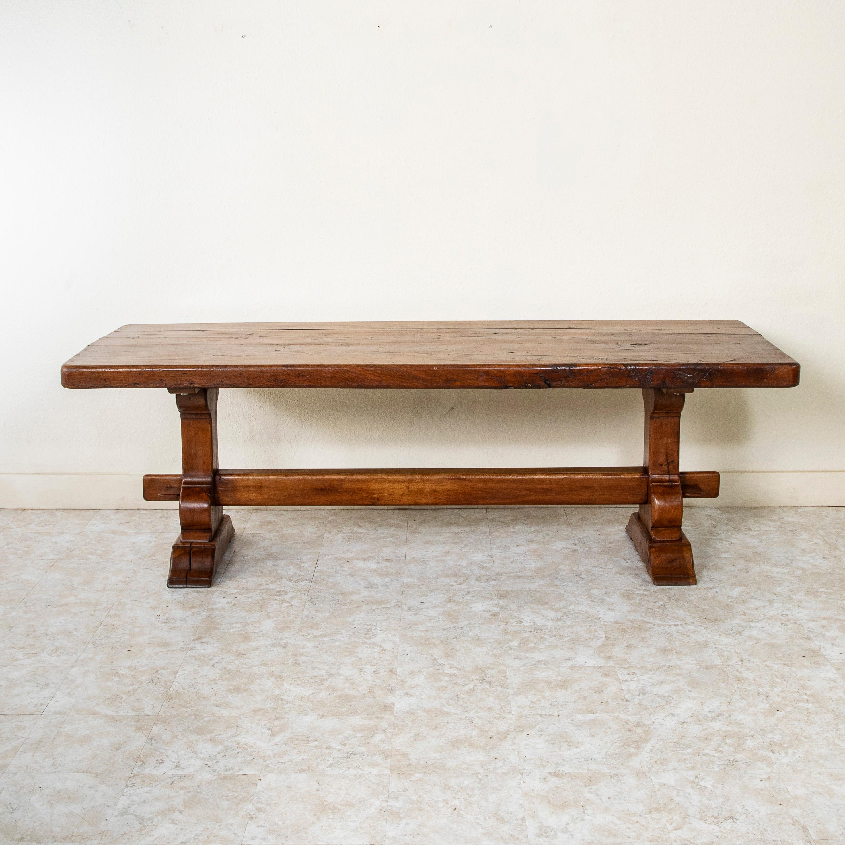 Found in the region of Normandy, France, this large artisan-made oak monastery table or dining table from the early twentieth century features an impressive 3.25 inch thick hand pegged top constructed of four planks of wood. The table rests on a