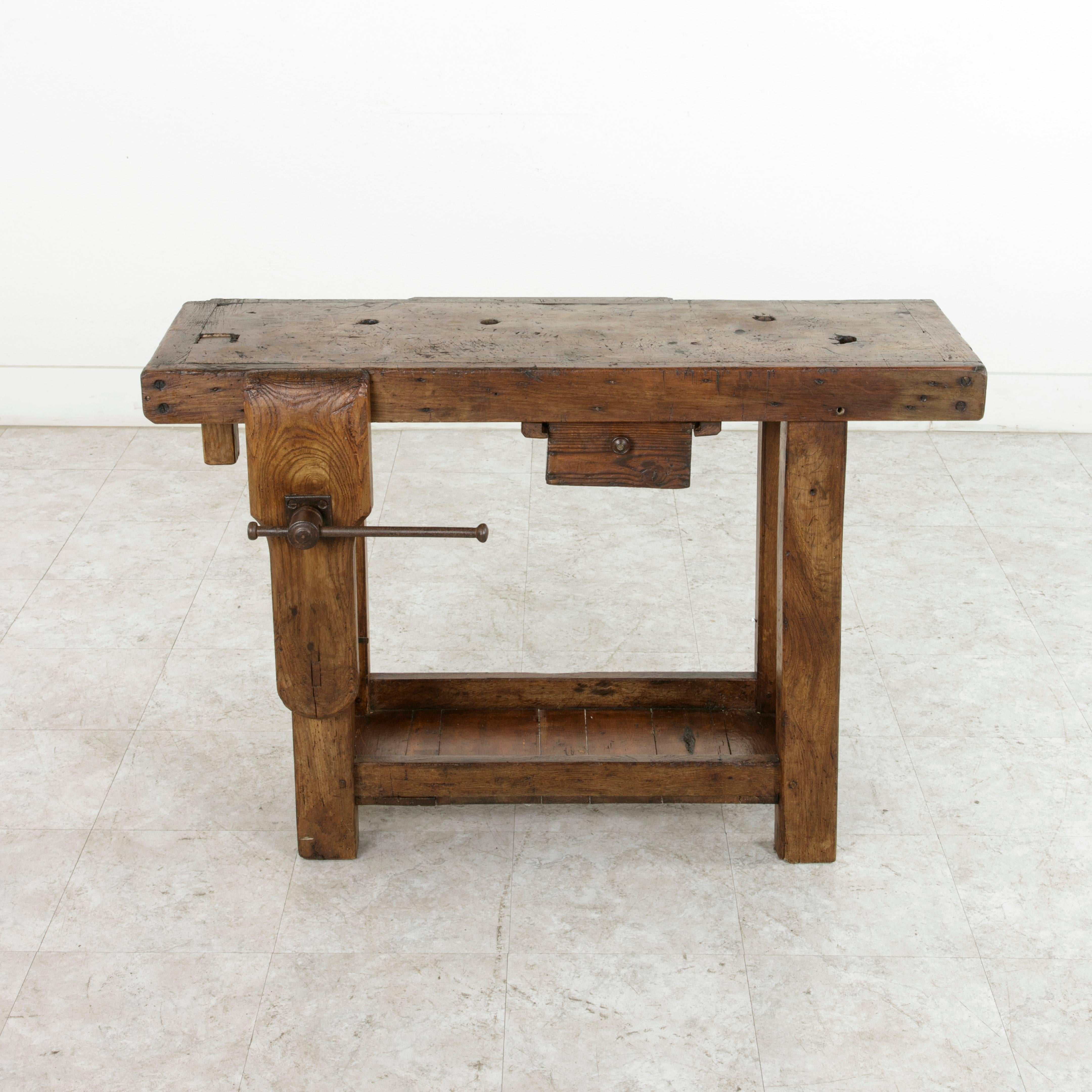 This early 20th century workbench from Normandy, France, is constructed of solid oak and beech and features a three inch thick top with a single lower drawer. Two slots at the back of the workbench were used to hold tools. The back of its drawer