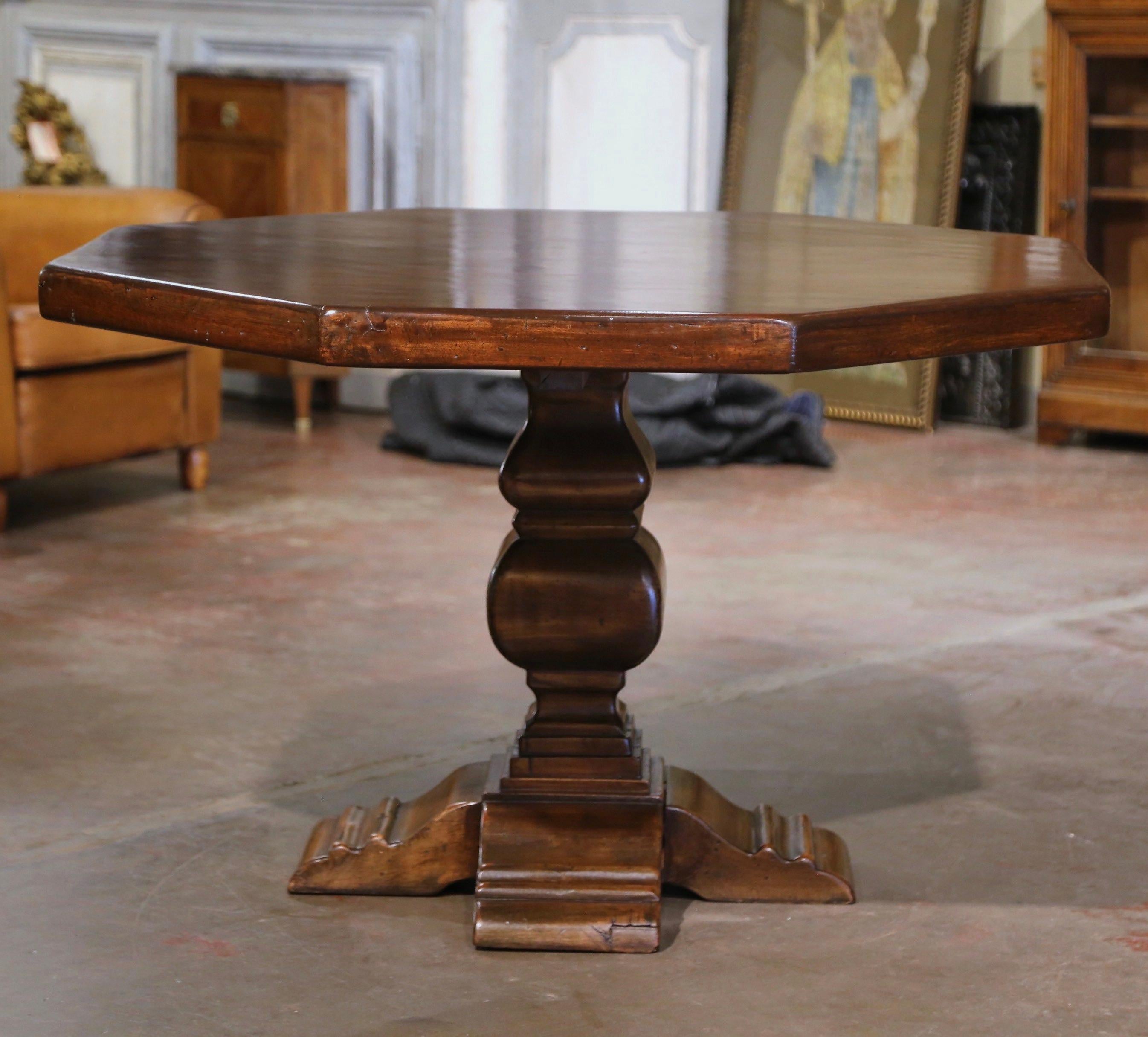 Decorate a breakfast room with this elegant antique table. Crafted in France circa 1920, and built of solid walnut enhanced with a beautifully distressed patina throughout, the table stands on a sturdy carved trestle base, supported by carved molded