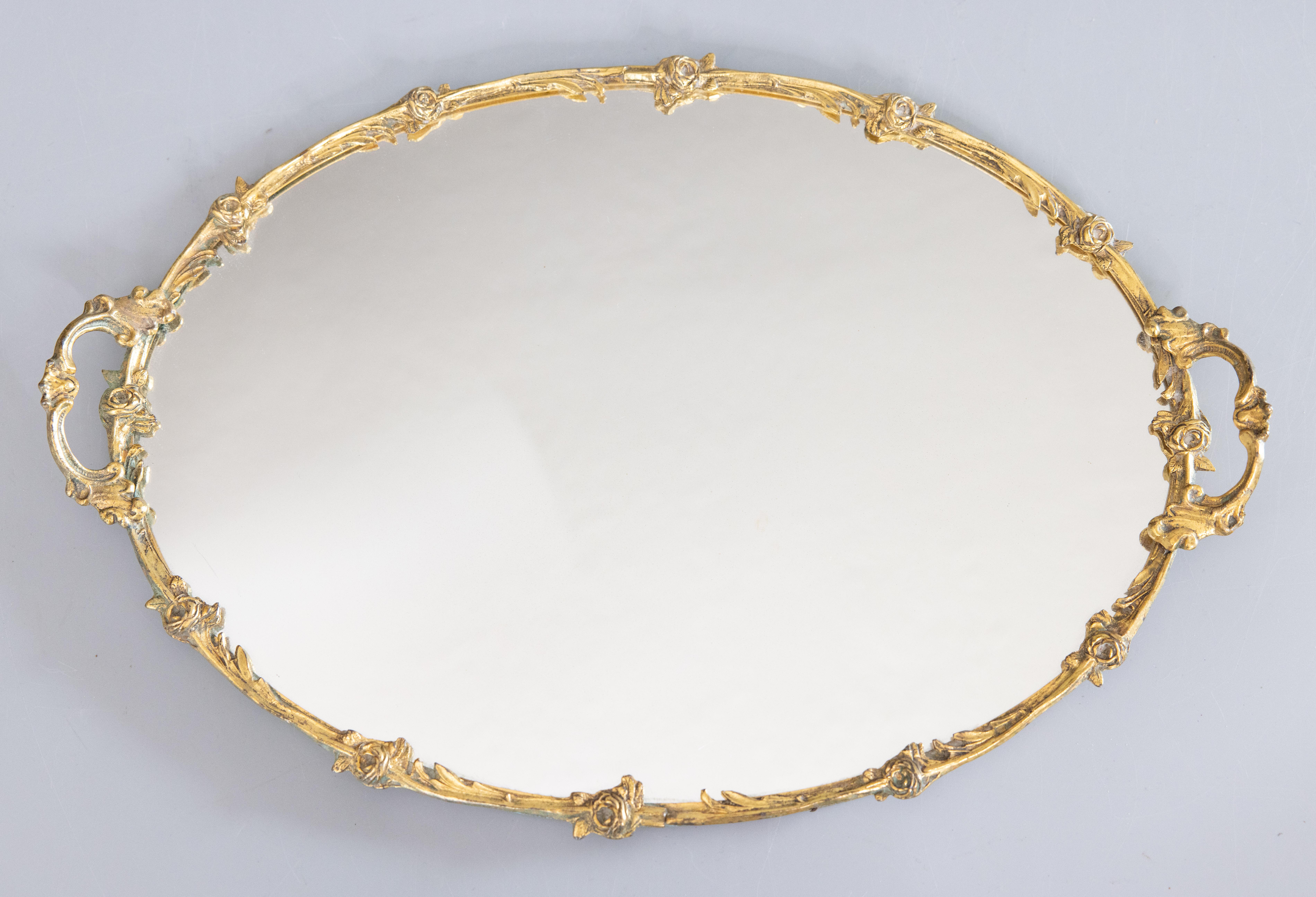 A stunning French antique ormolu gilt brass mirror plateau with ornate handles surrounded by a garland of scrolling leaves and delicate rosettes in a lovely gilt patina. It would look gorgeous displayed on a buffet with wine glasses or as a vanity