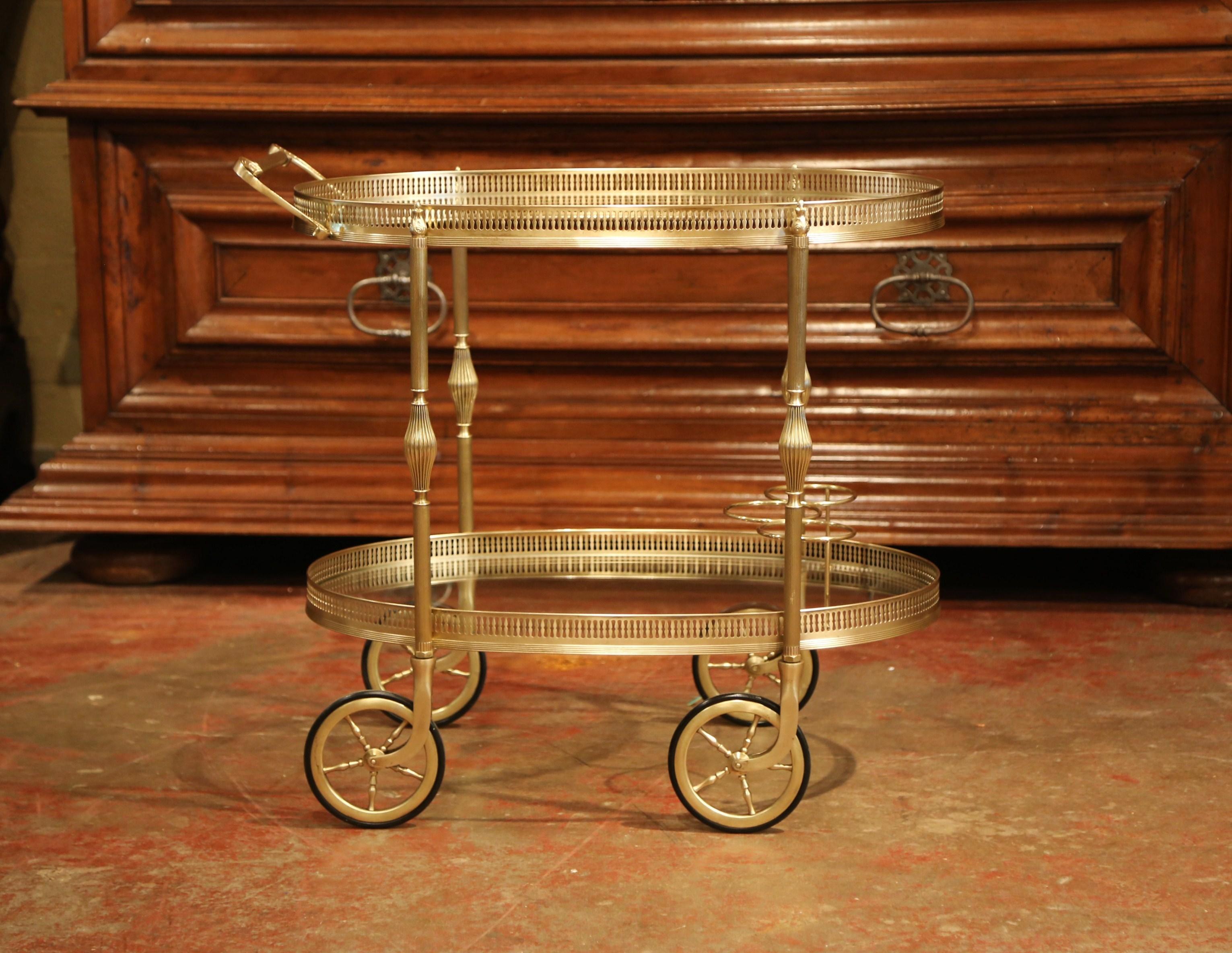 
This beautiful, vintage rolling bar cart was created in France, circa 1930. The desert table has a brass frame, small round wheels with rubber tires, and two plateaux topped with glass surfaces. The top deck features a shaped utilitarian handle, a